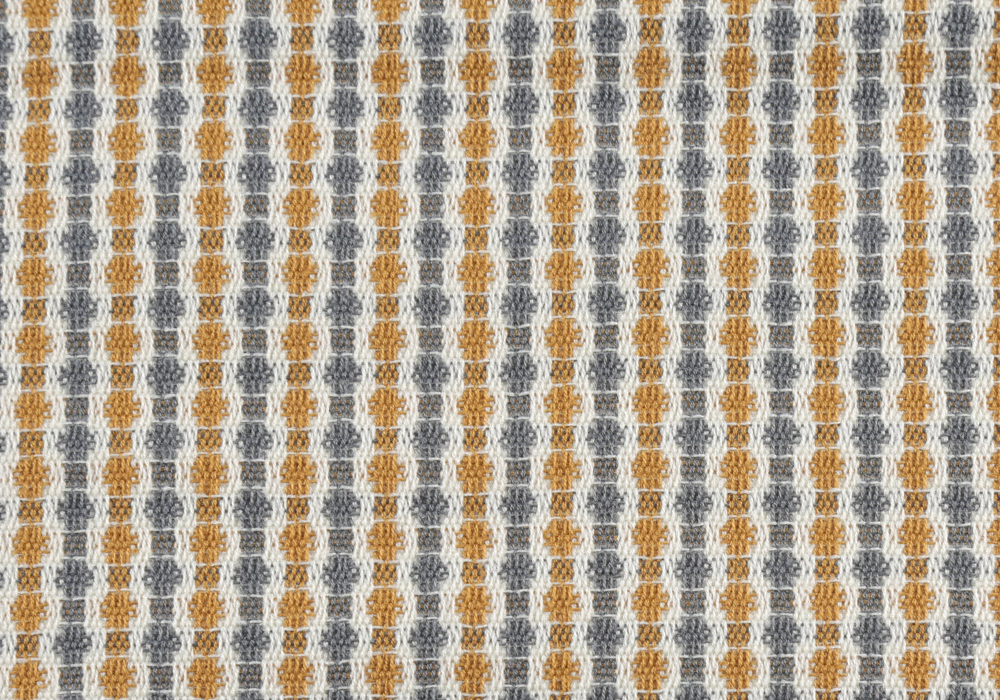 Closeup of textured woven fabric with a repeating diamond pattern in gold and gray threads