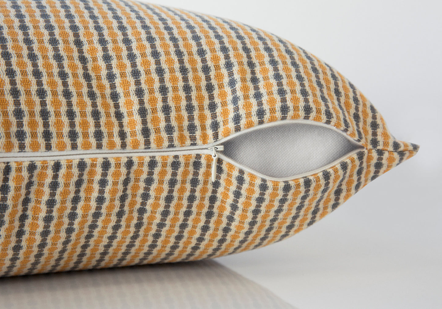 Textured yellow and gray patterned throw pillow with zipper detail
