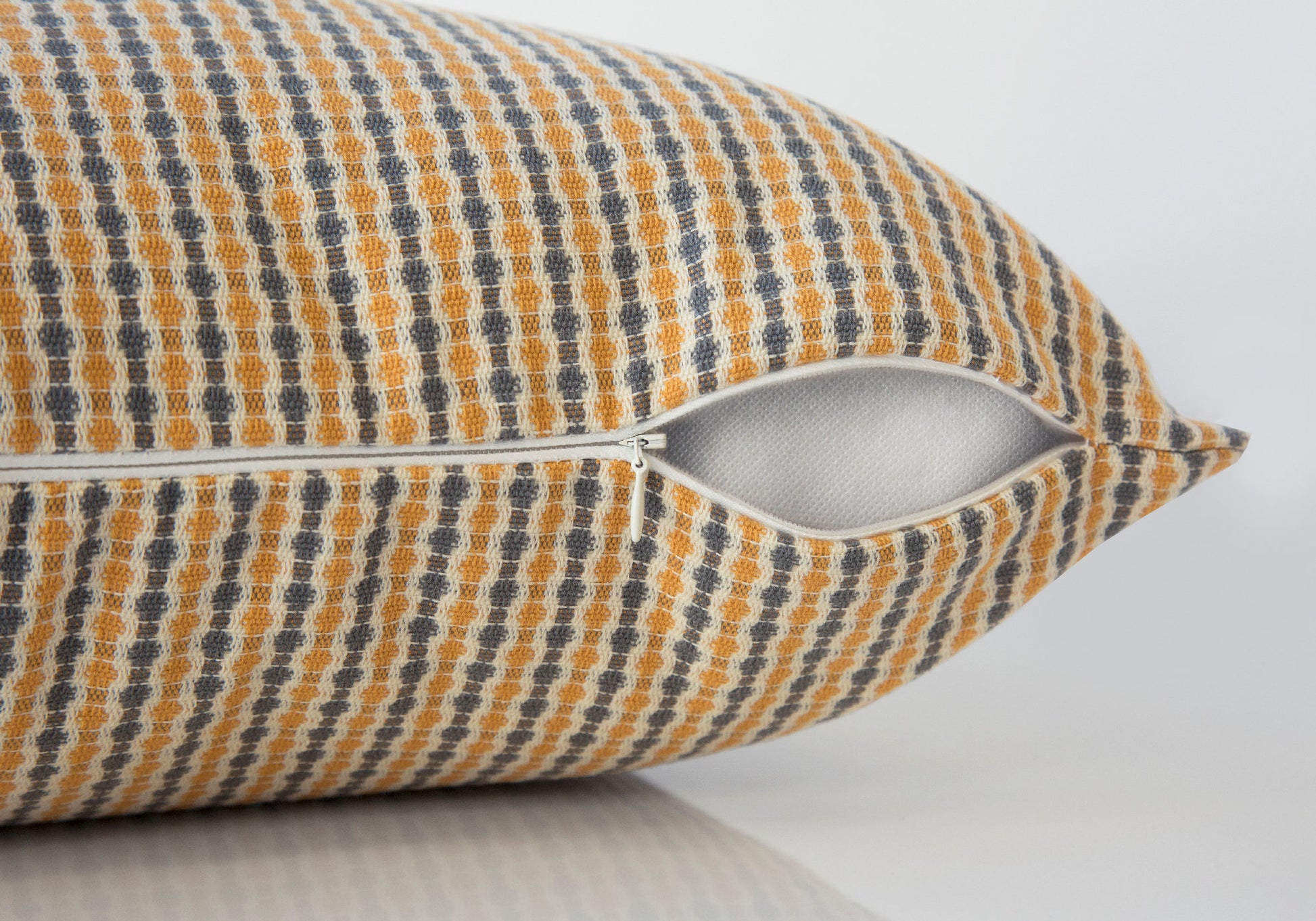 Textured yellow and gray patterned throw pillow with zipper detail