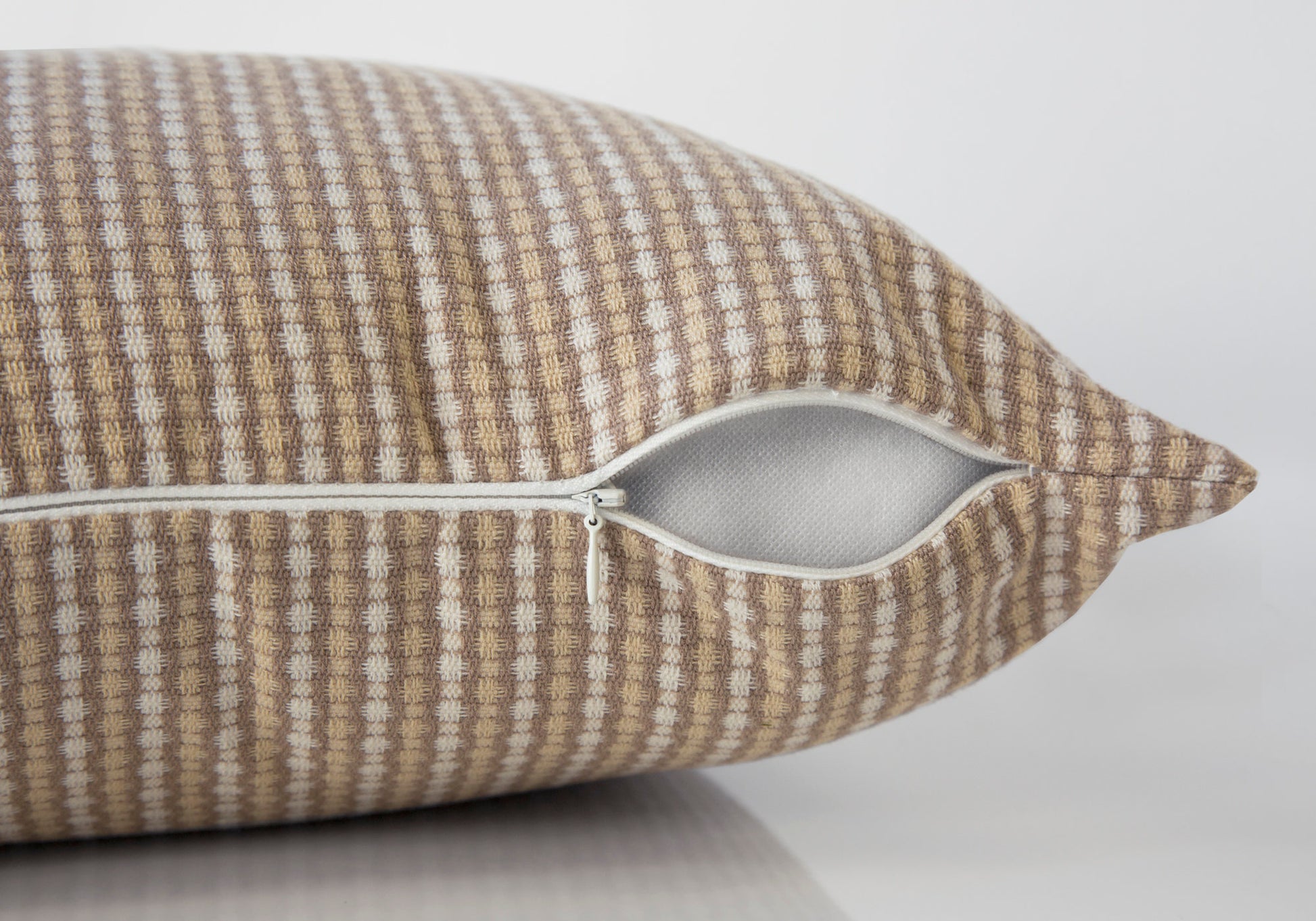 Textured beige and white checkered throw pillow with visible zipper closure