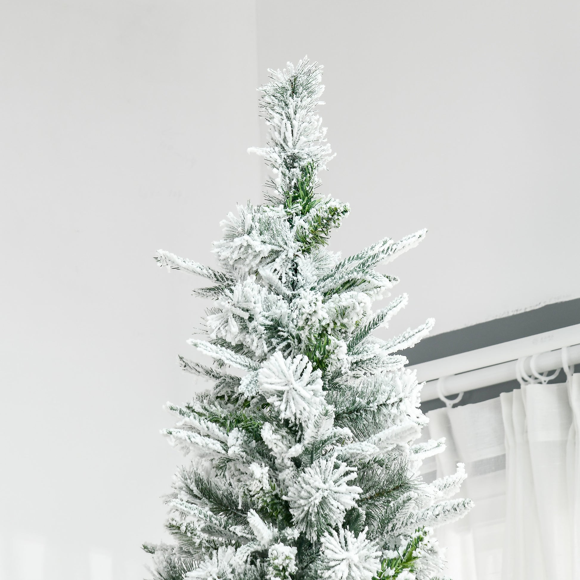 Flocked pine Christmas tree branches with realistic green needles and fluffy white snow coating