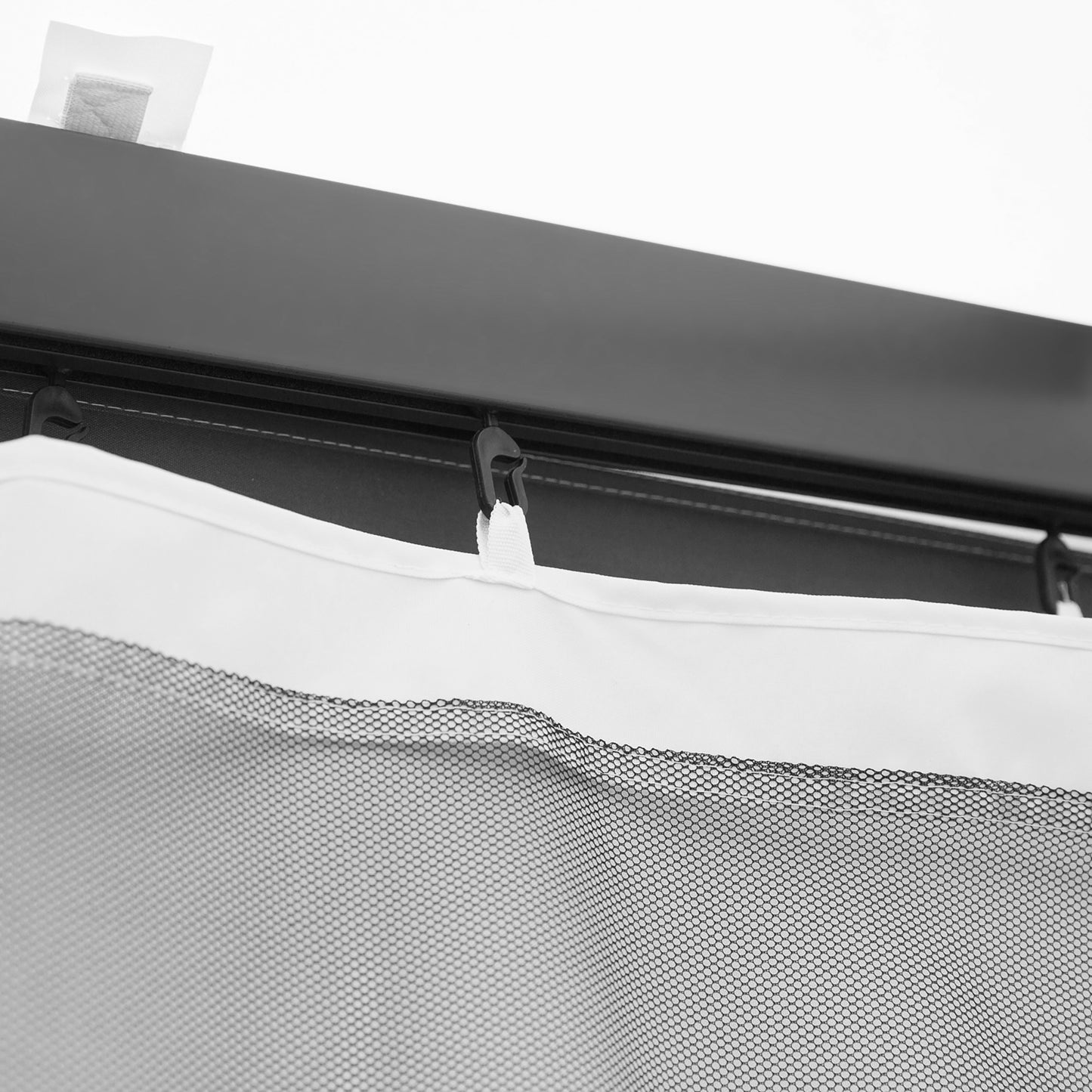 Closeup of black hook attaching white mesh mosquito net to a dark gazeboo frame