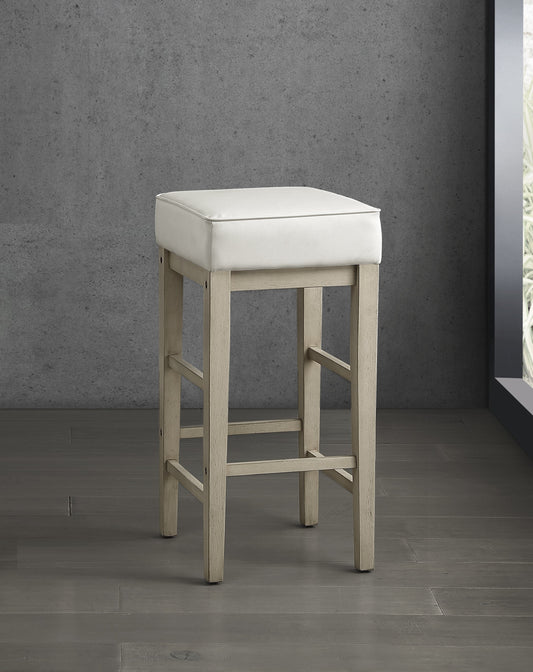 White upholstered backless bar stool with a light wood frame and four legs