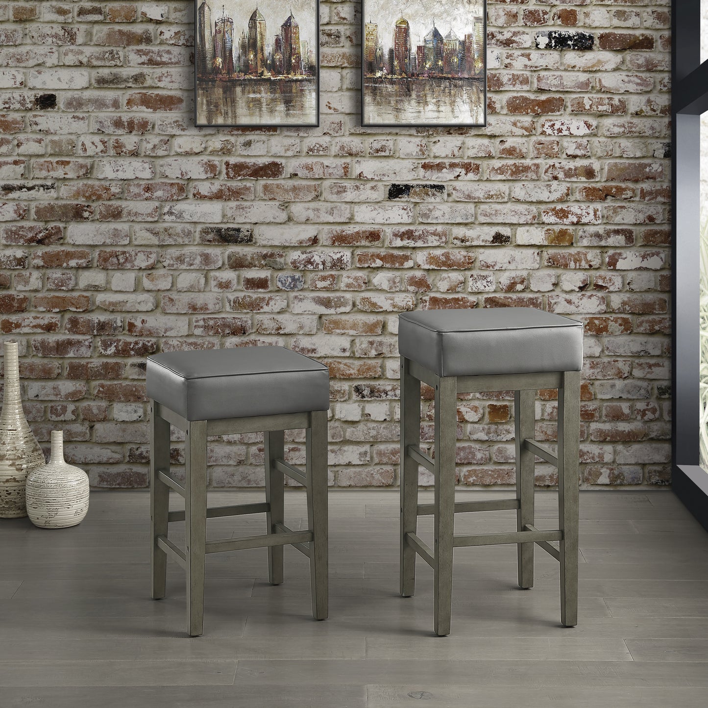 Two grey leatherette upholstered bar stools with distressed grey wood frames perfect for a modern kitchen