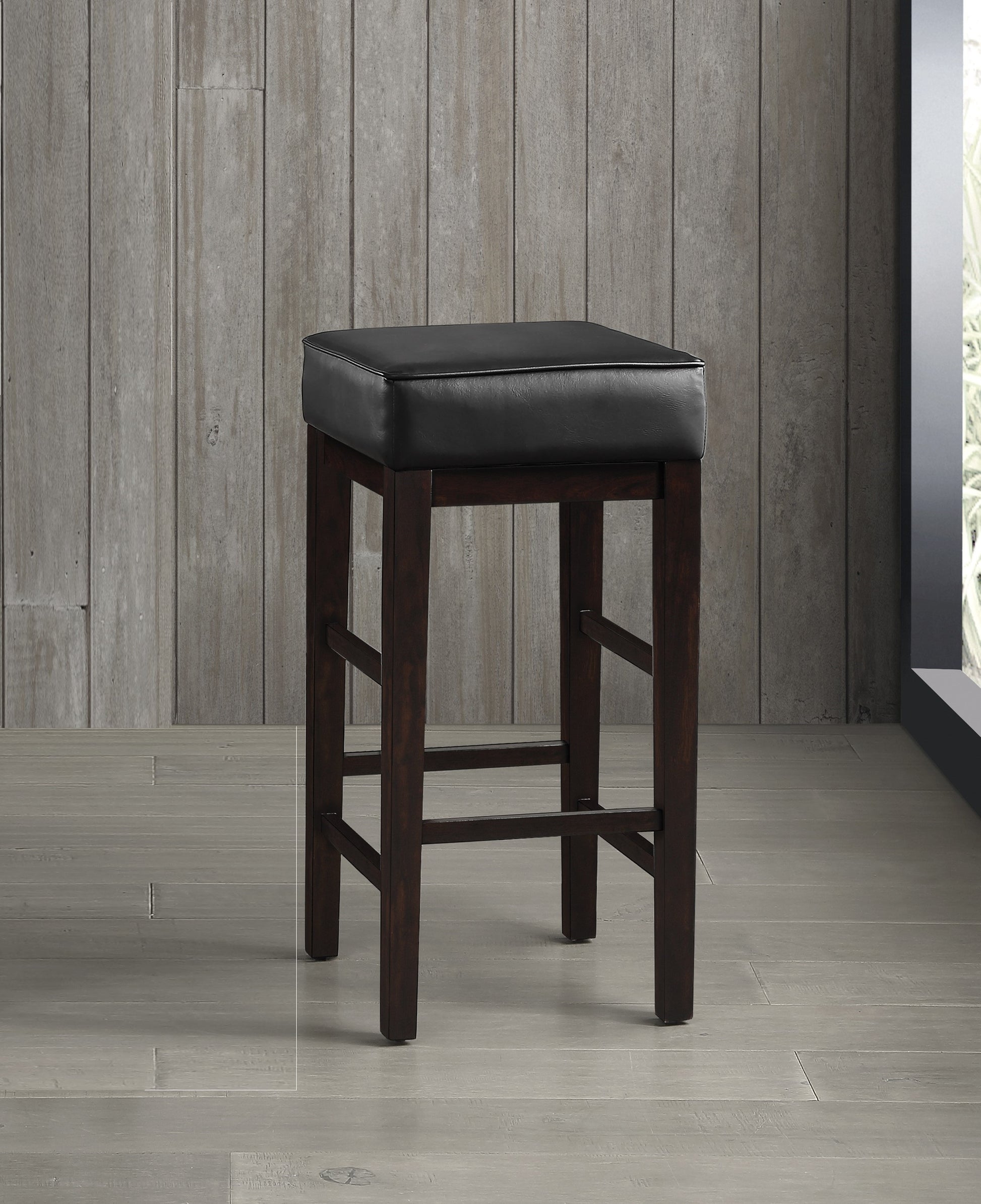 Dark brown wooden bar stool with padded black leather seat and footrest