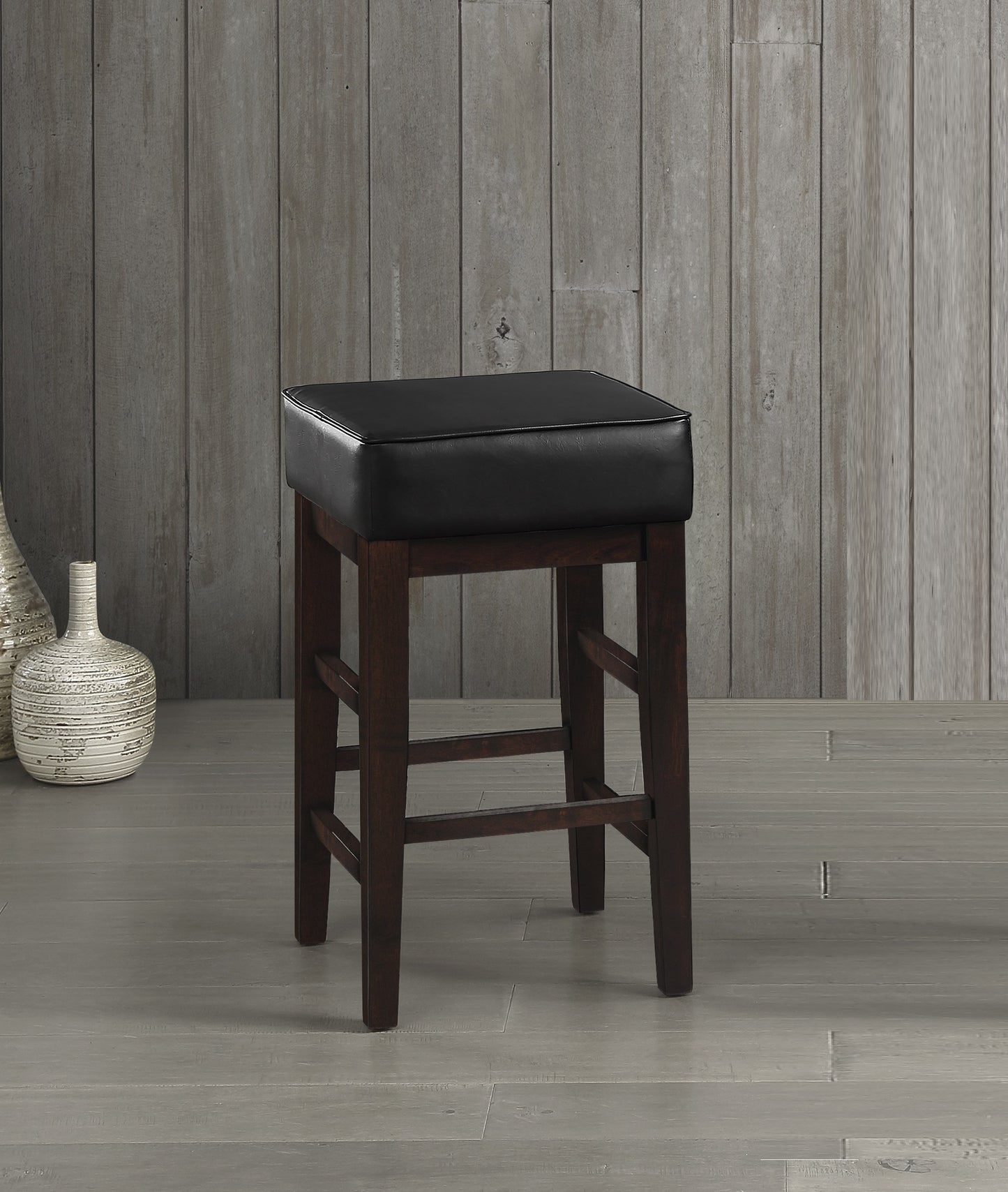Dark brown wood bar stool with black faux leather seat