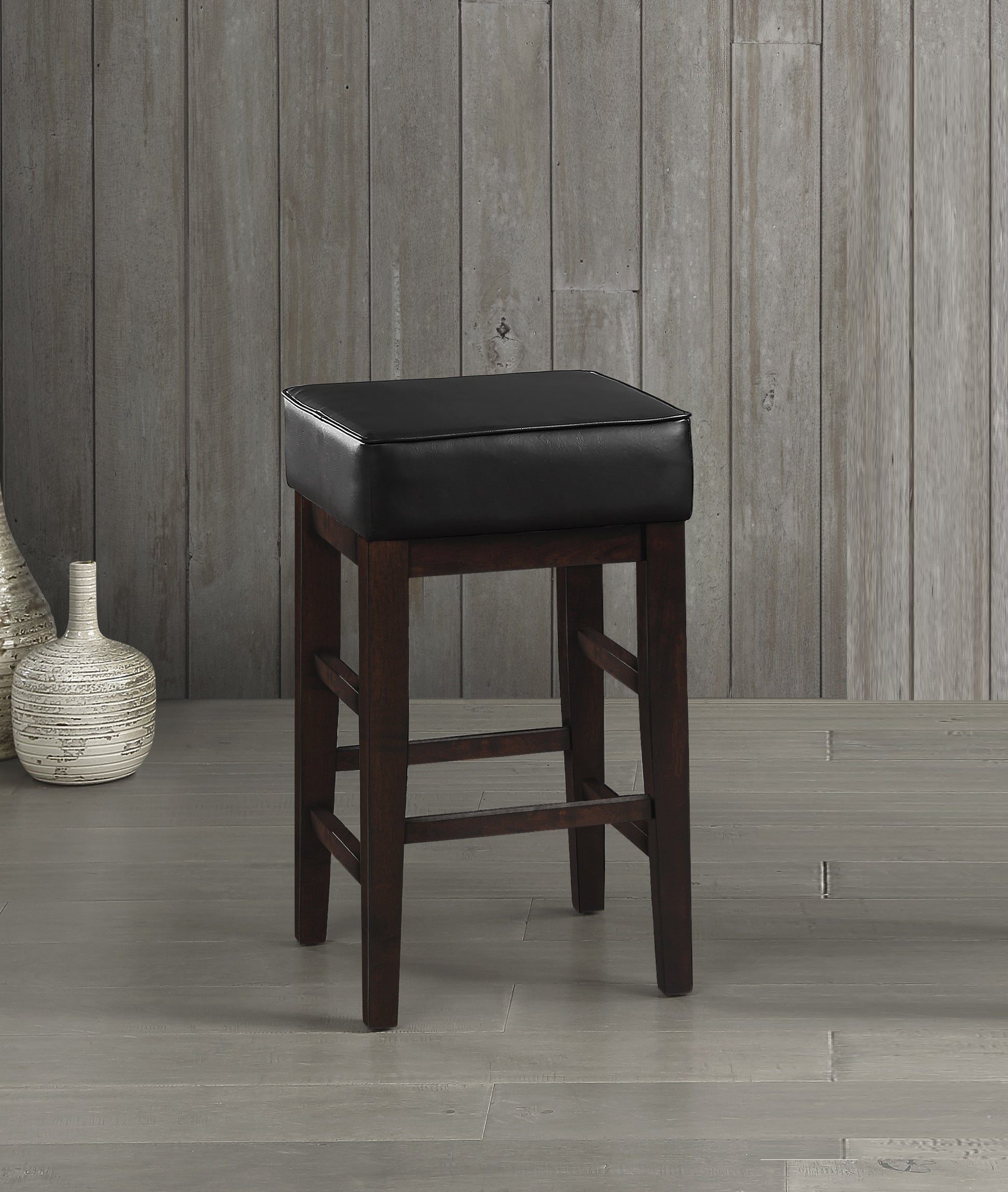 Dark brown wood bar stool with black faux leather seat