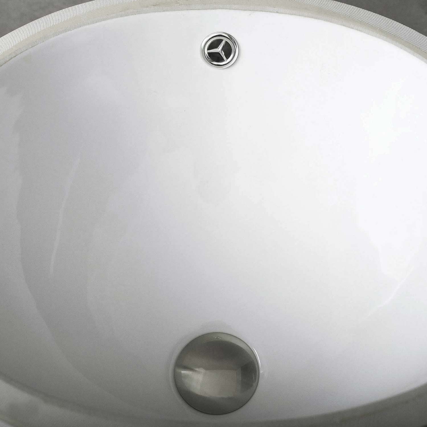 White ceramic undermount sink with brushed nickel drain assembly perfect for modern bathrooms