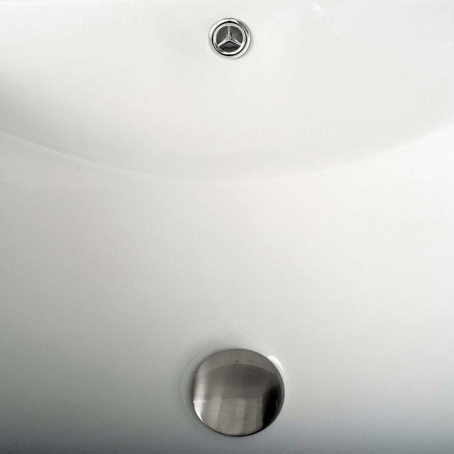 Closeup of a modern white ceramic sink with a brushed nickel drain