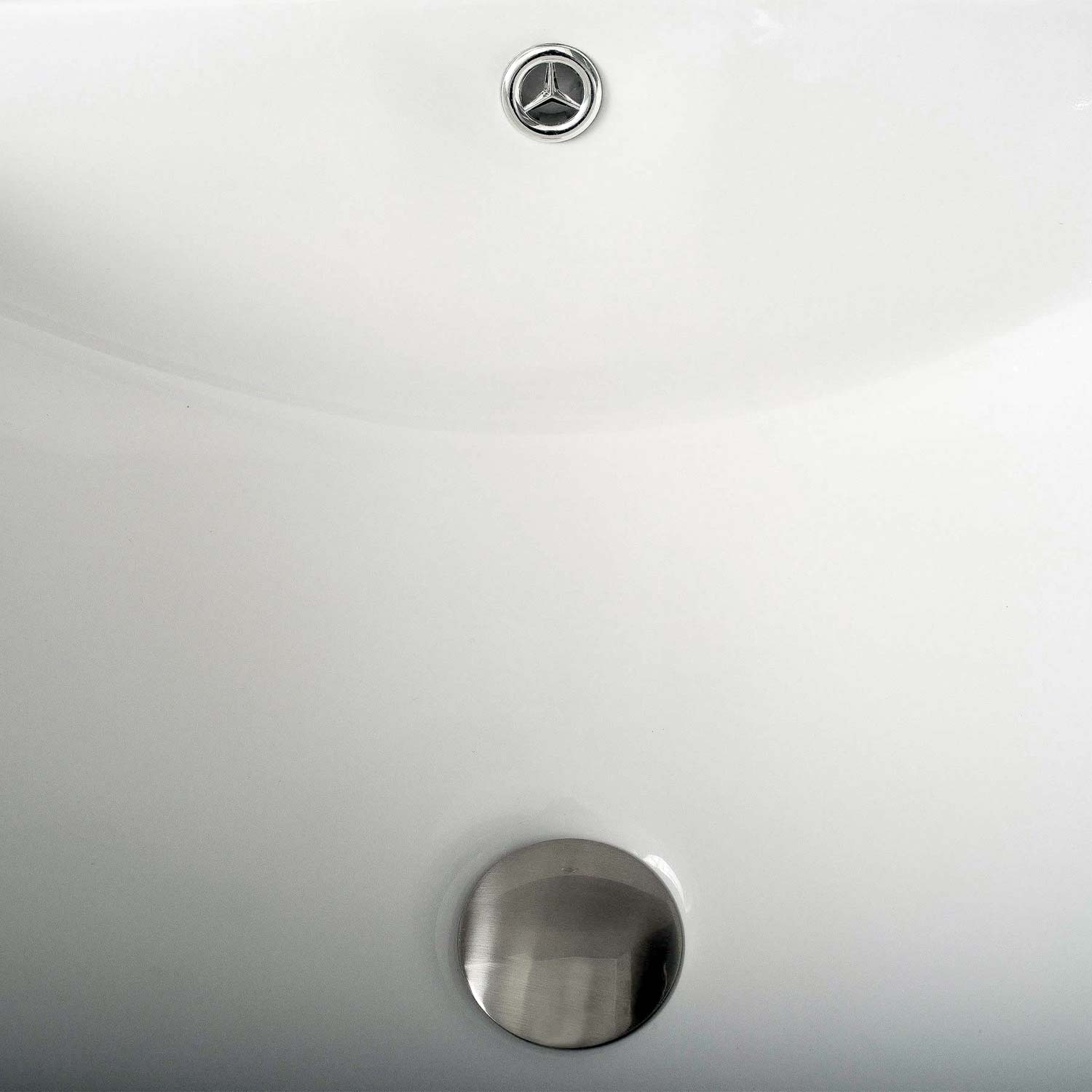 Closeup of a modern white ceramic sink with a brushed nickel drain