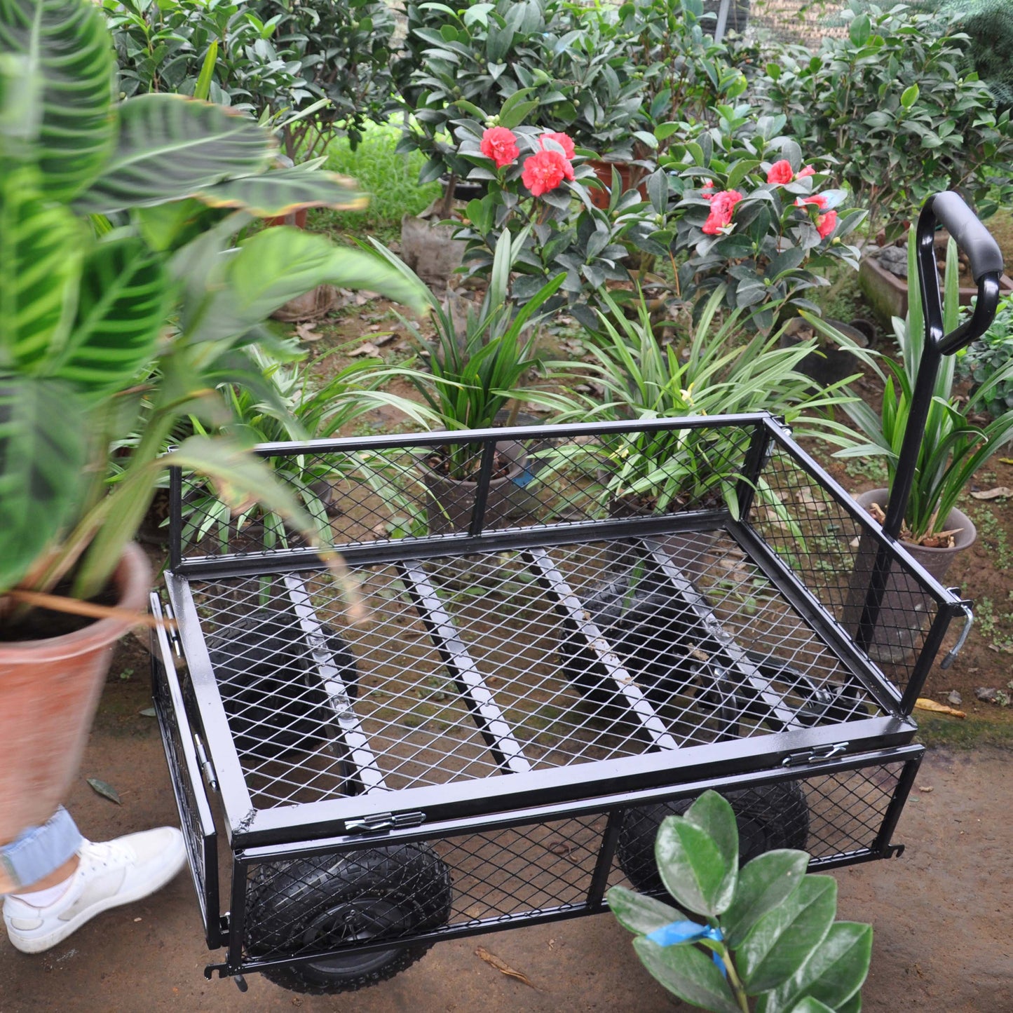 Heavyduty black garden cart with mesh sides and large wheels for hauling supplies