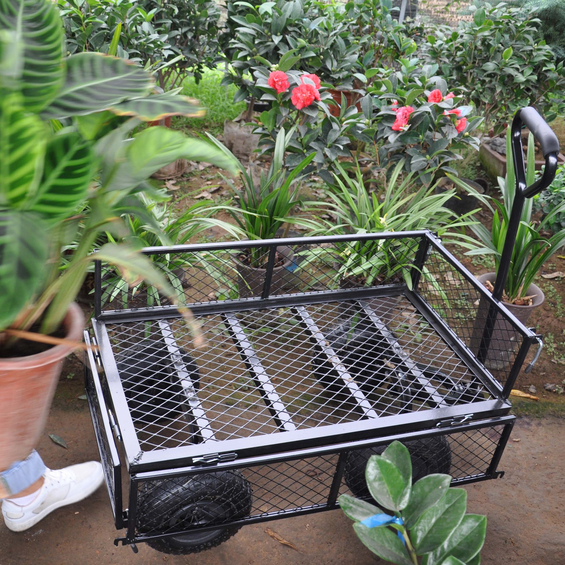 Heavyduty black garden cart with mesh sides and large wheels for hauling supplies