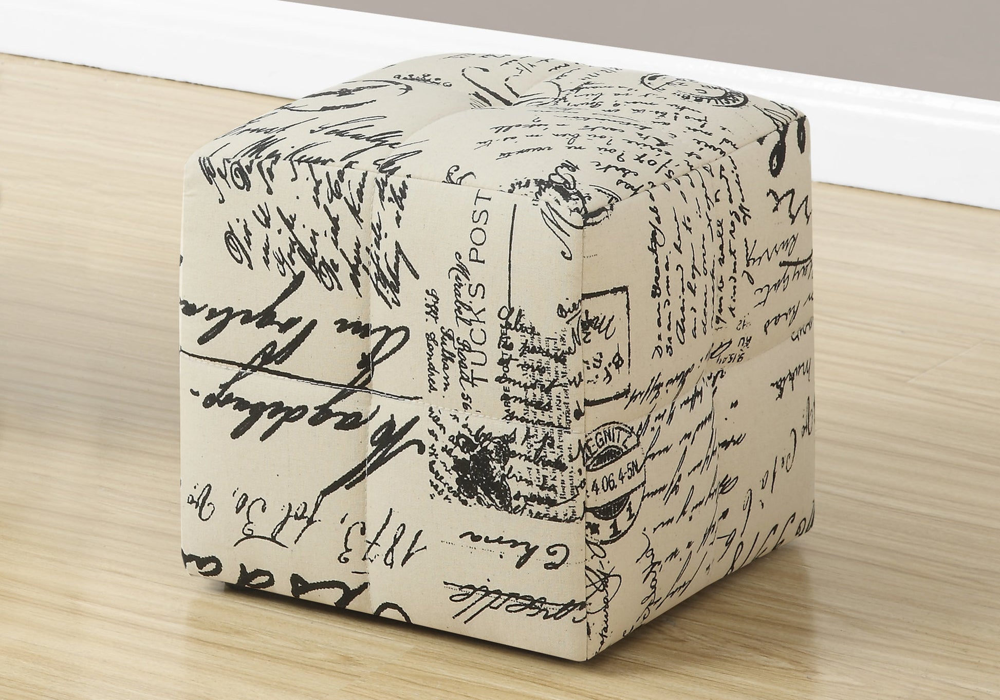 Cream fabric ottoman with black script pattern perfect for footrest