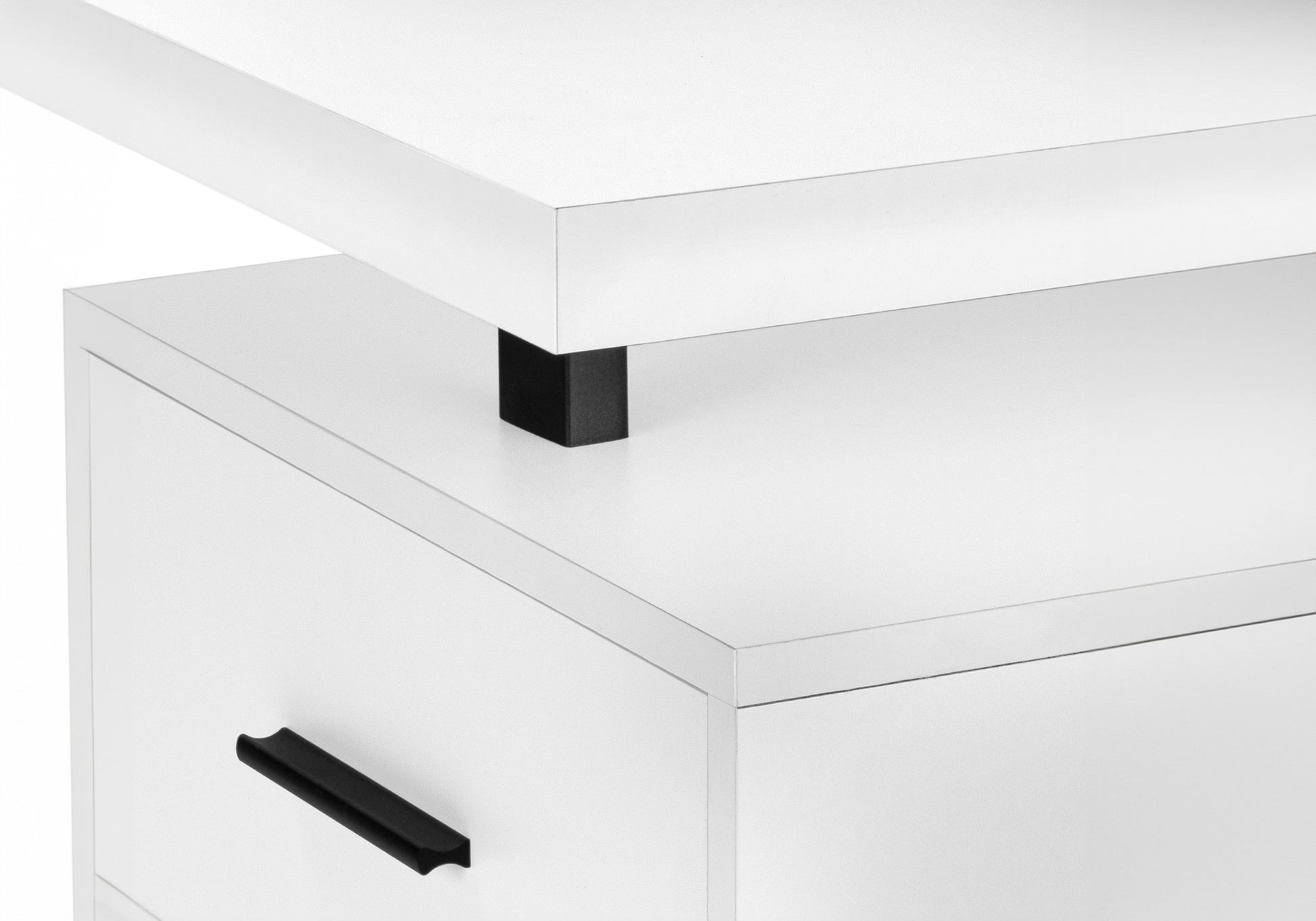 Closeup of a modern white desk with a black handle on a drawer