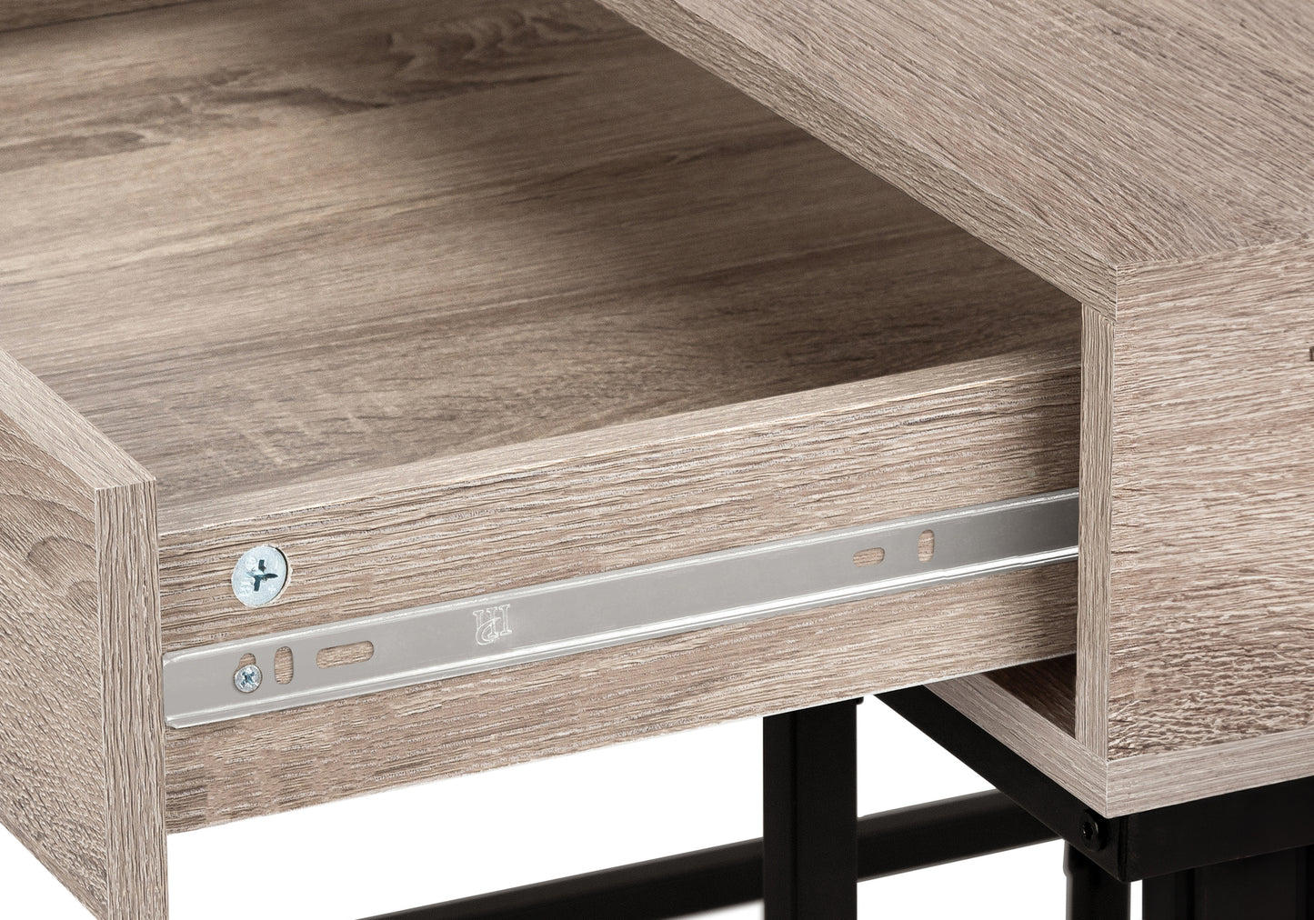 Closeup of an open drawer on a light oak wood desk showing metal drawer slides