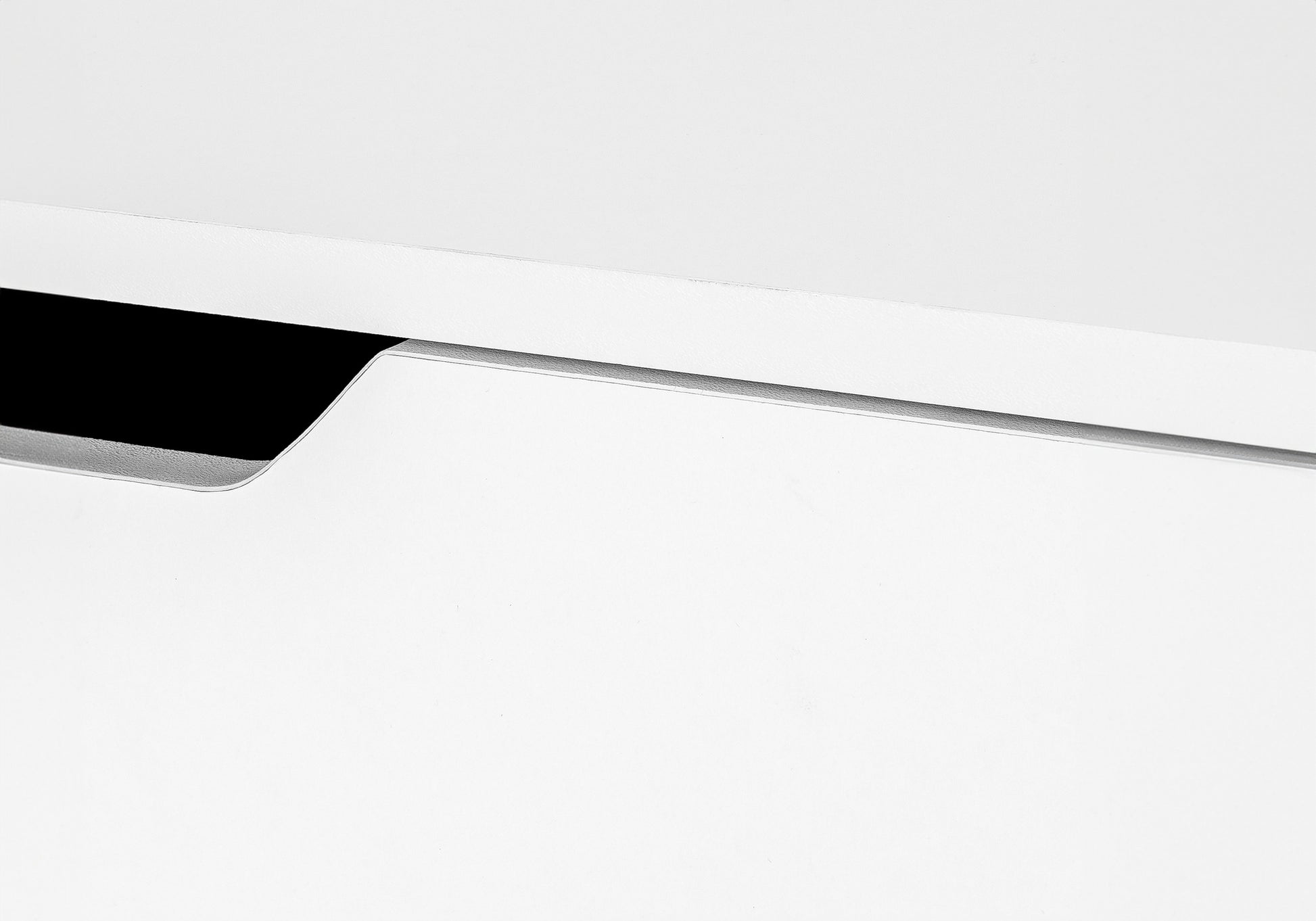 Closeup of a sleek white drawer with a minimalist inset metallic handle