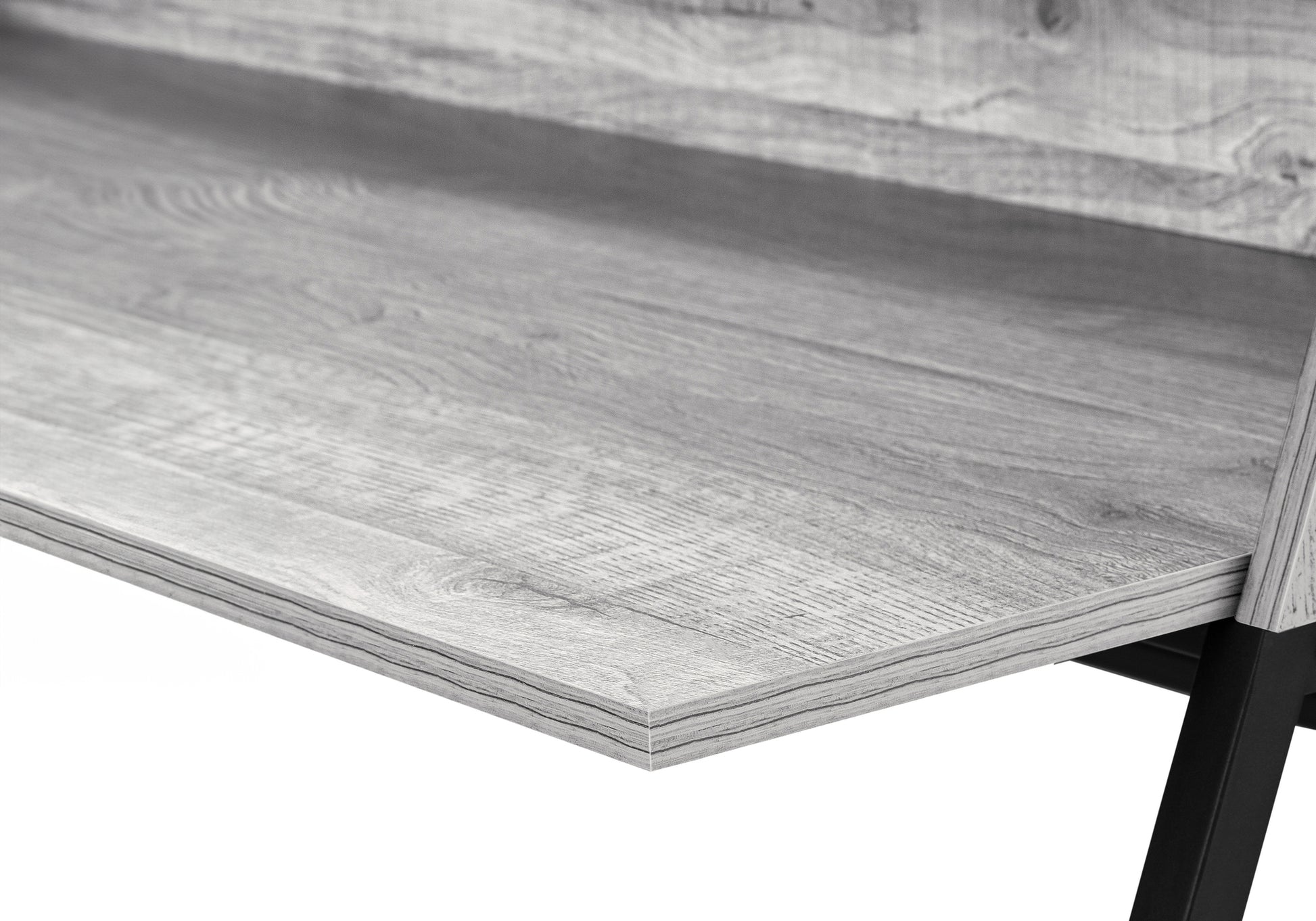 Closeup of grey wood grain laminate desk surface with black metal legs