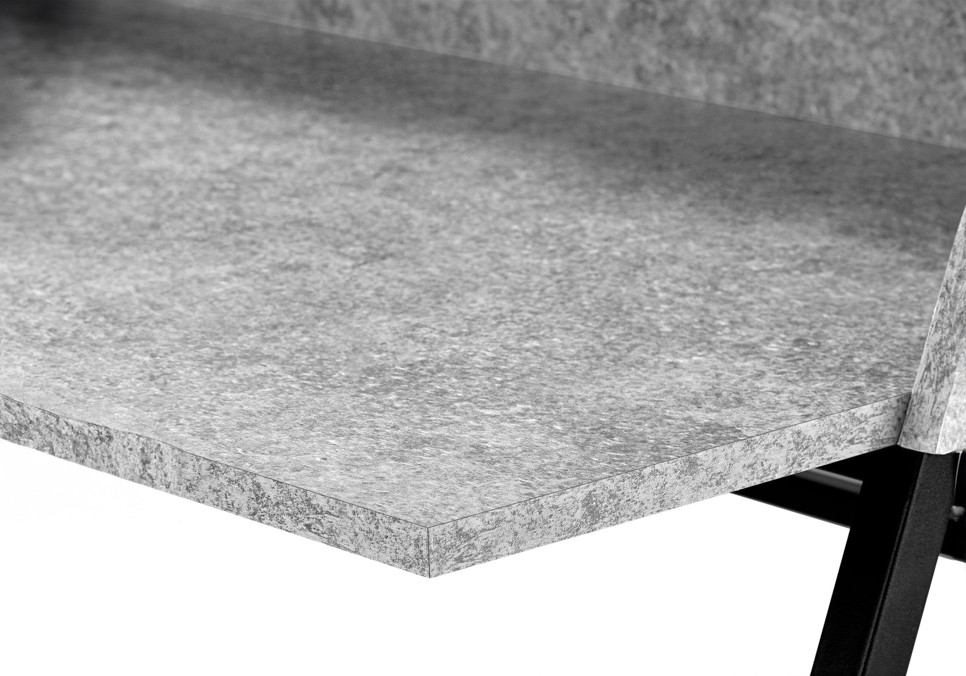 Closeup of a textured gray concrete tabletop edge with a dark metal frame