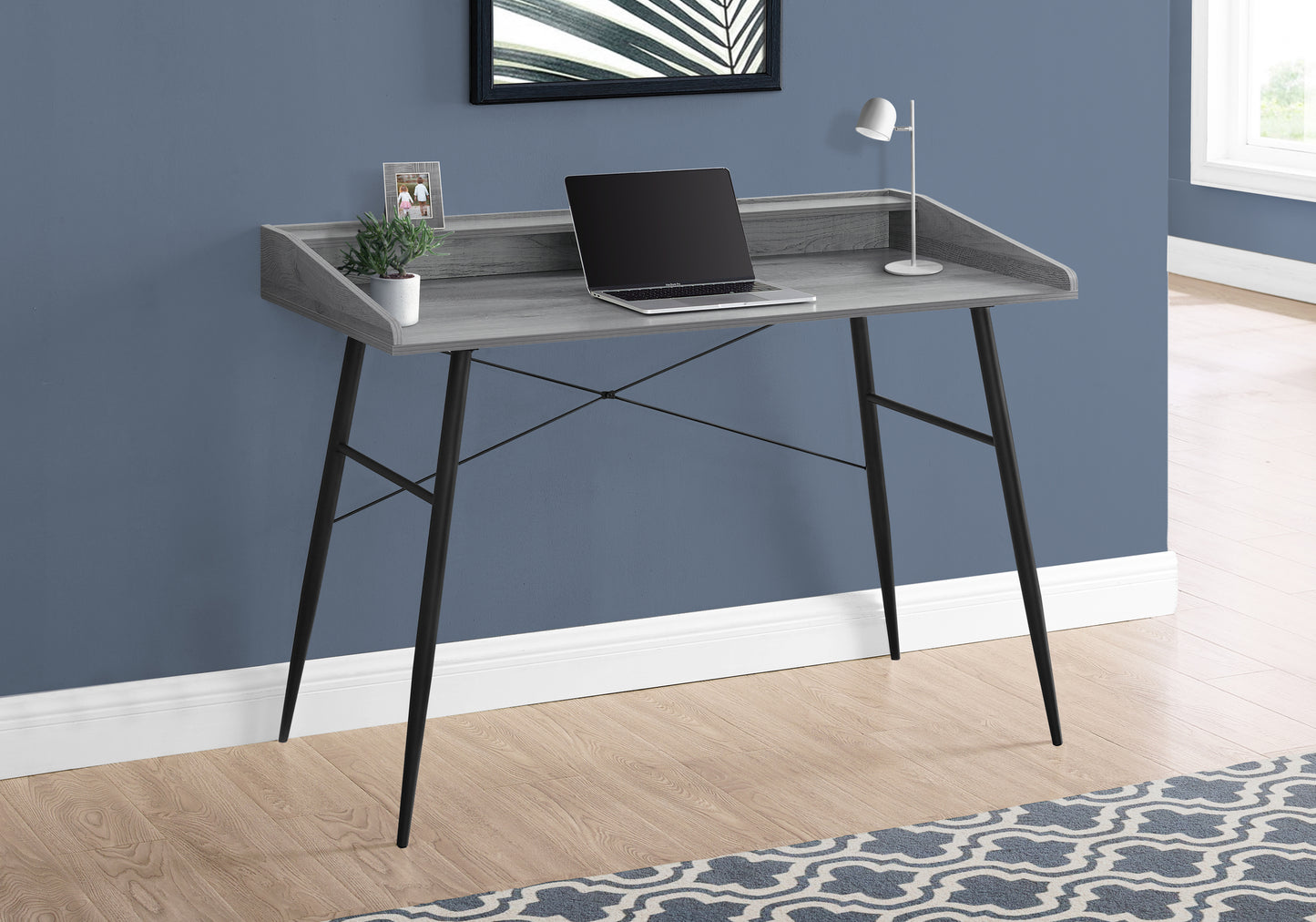 Modern grey wood desk with black metal legs and a laptop for home office