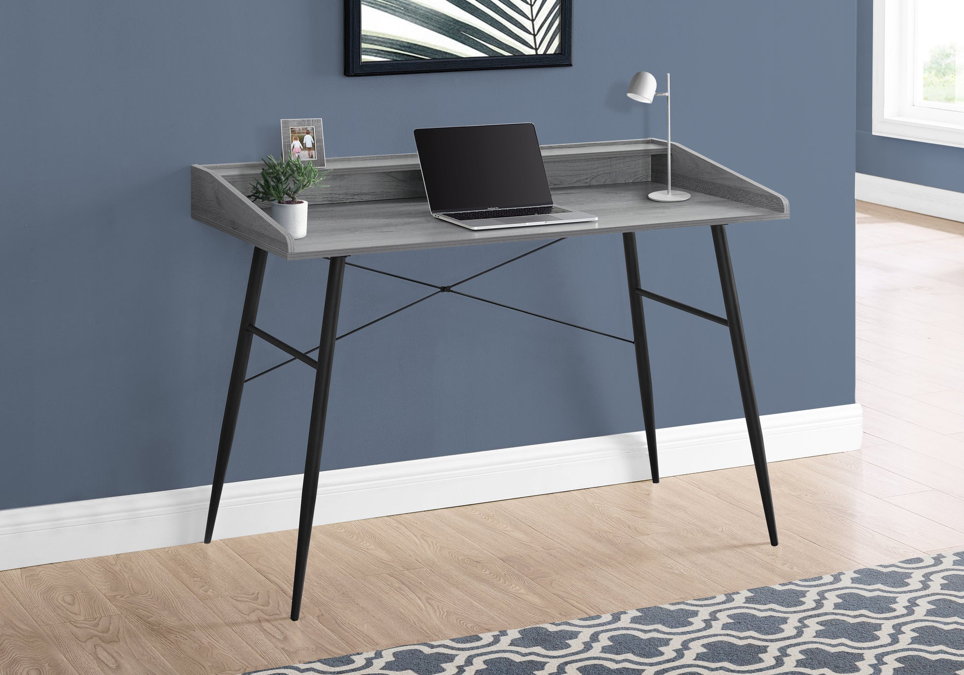 Modern grey wood desk with black metal legs and a laptop for home office
