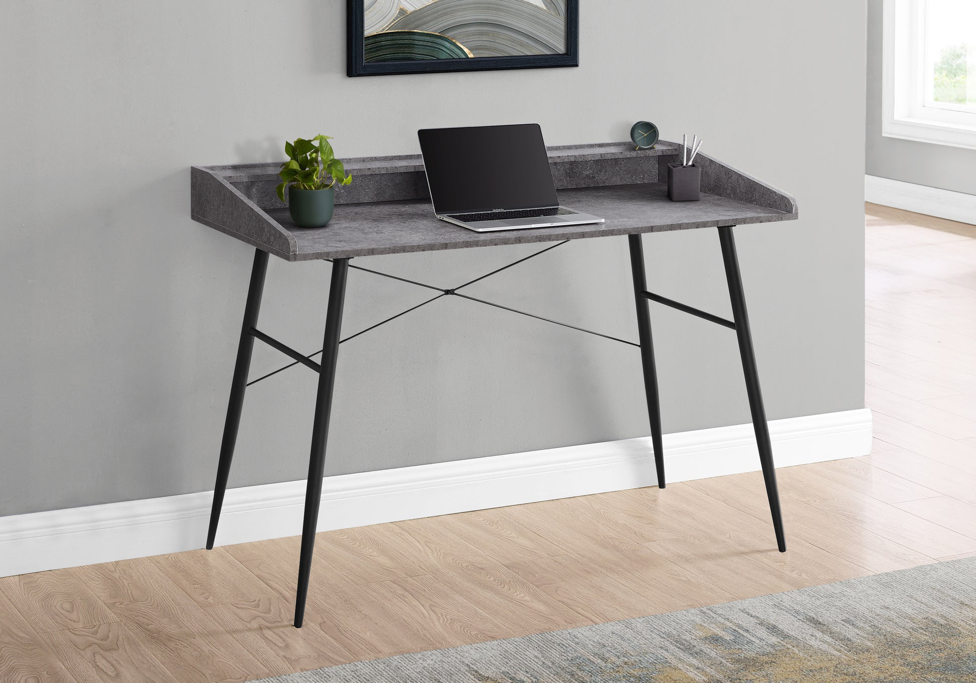 Modern gray faux stone writing desk with black metal legs and laptop