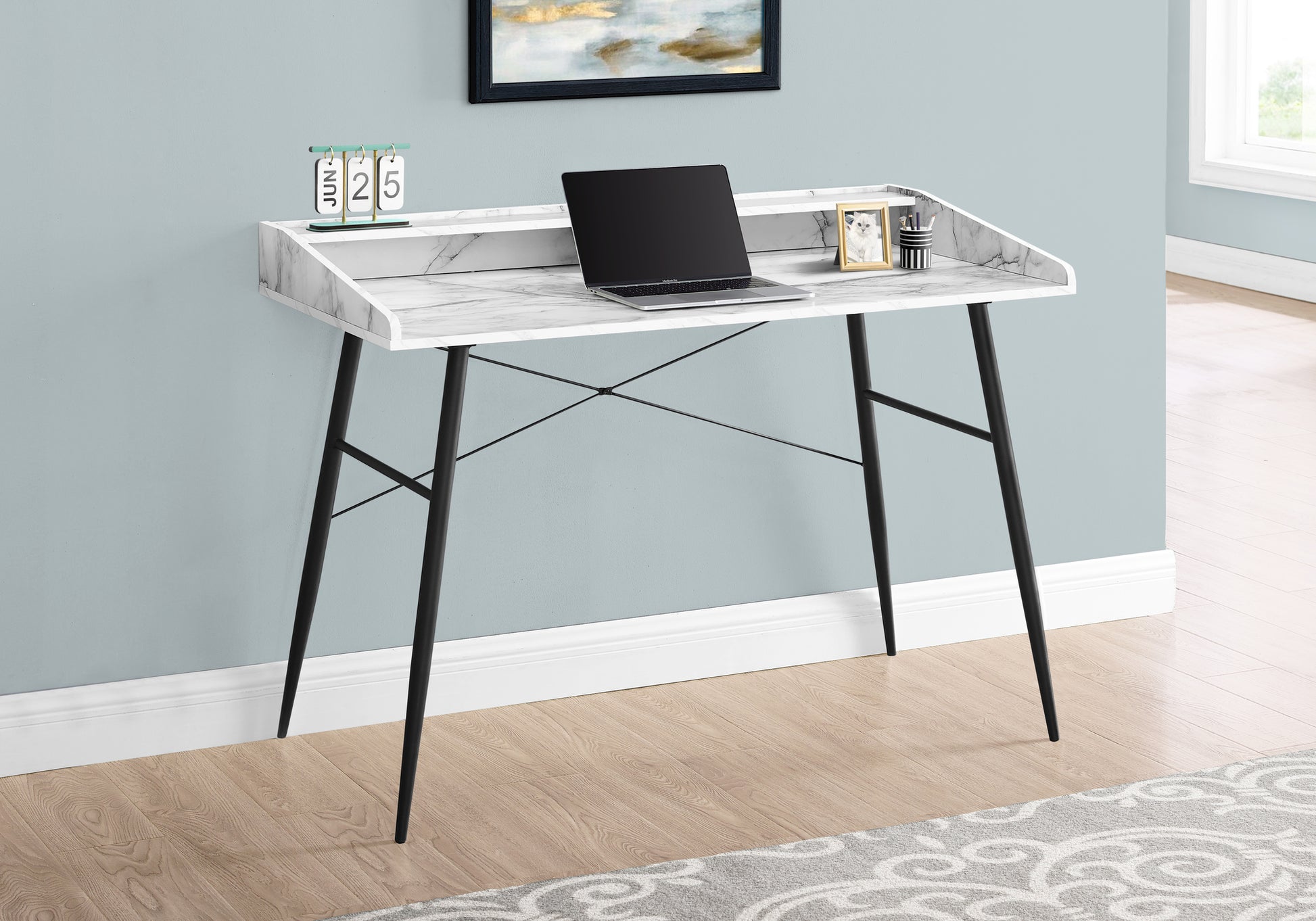 Marble top writing desk with black metal legs and a laptop on its surface
