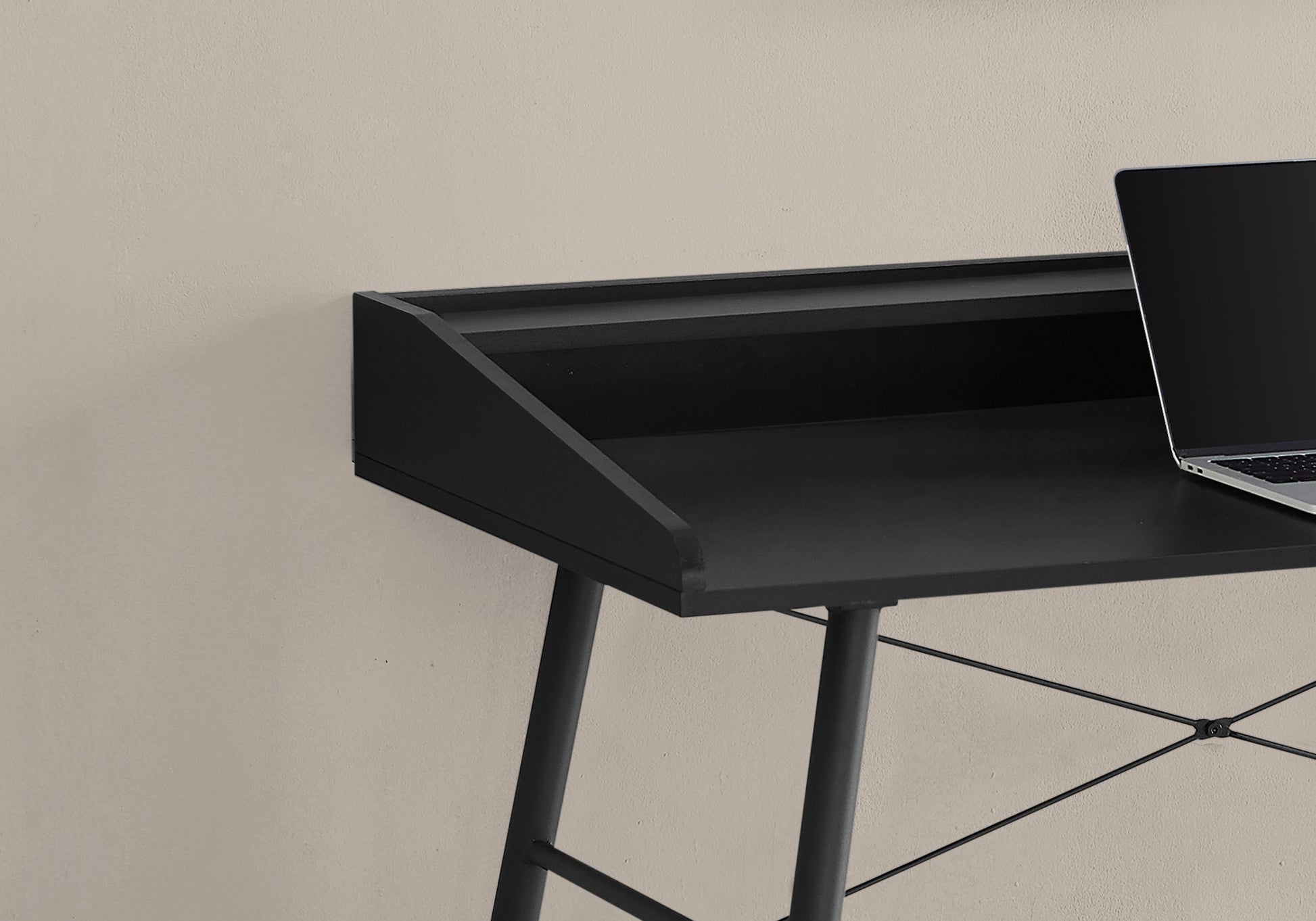 Minimalist black writing desk with angled riser and sleek metal legs
