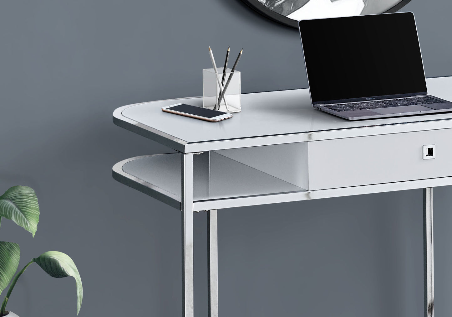 Sleek white desk with polished chrome legs featuring a drawer and open shelving