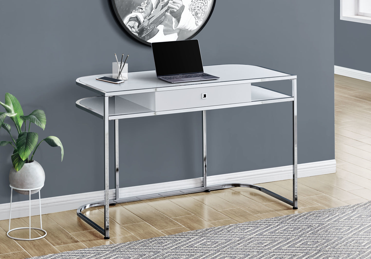 Sleek white and chrome writing desk with a drawer laptop and phone