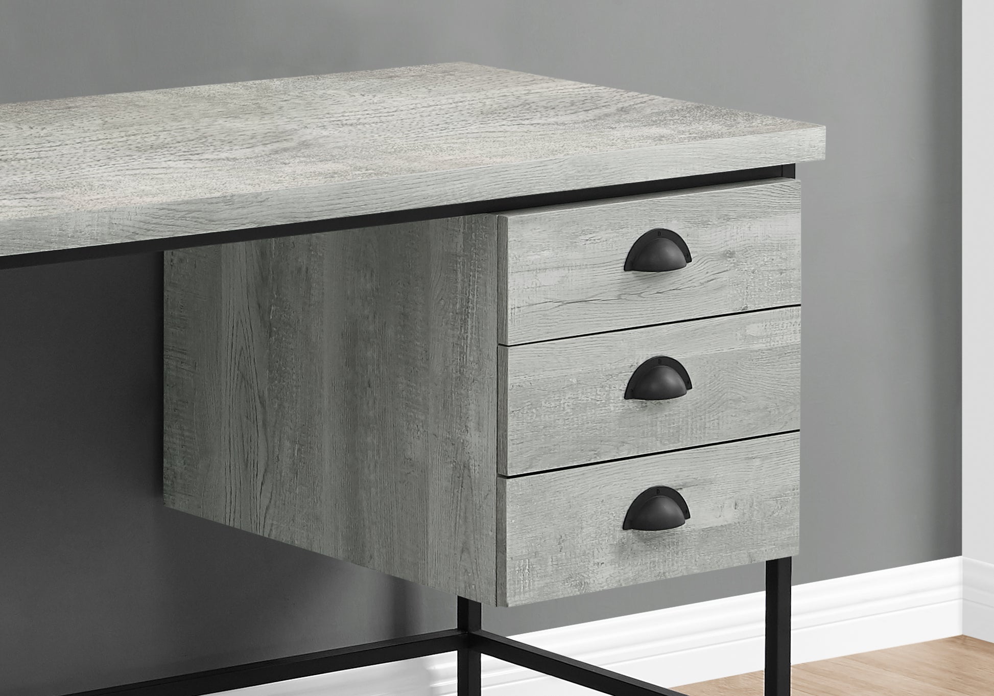 Gray wood grain desk with three drawers and black hardware