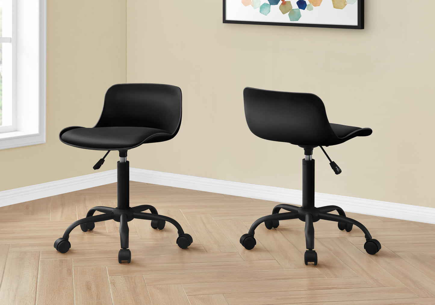 Two black ergonomic task chairs with casters on a light wood floor