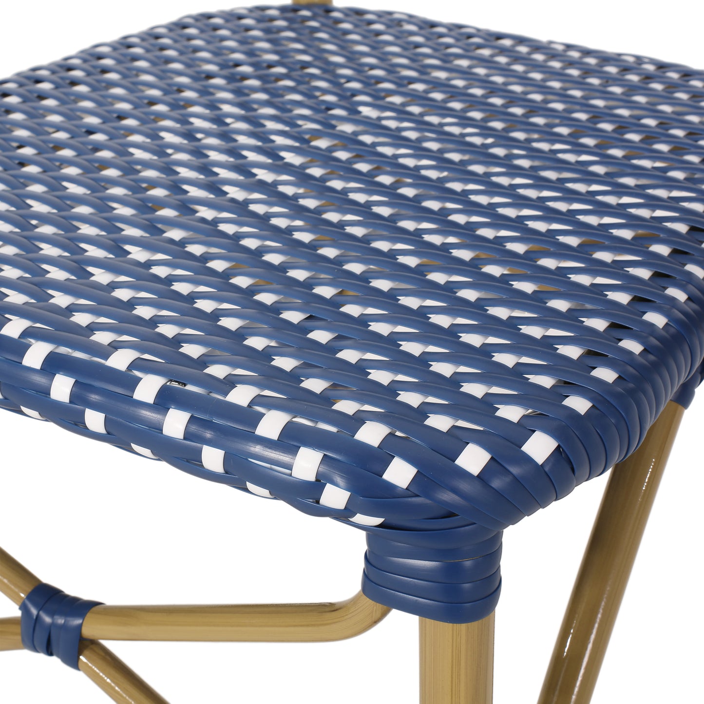 Close up of a blue and white woven bistro chair seat with gold metal legs