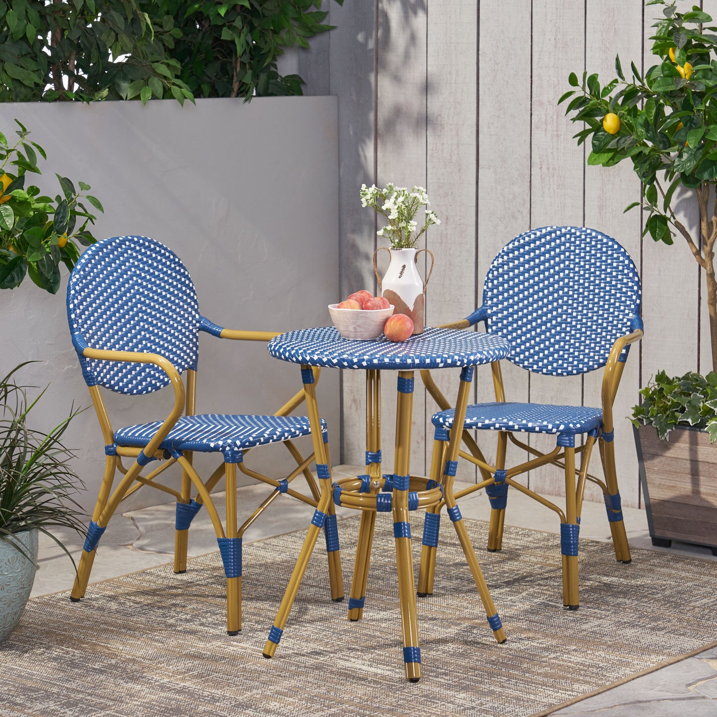 Blue and white wicker bistro set with gold legs on an outdoor patio
