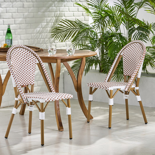 Two white and brown rattan bistro chairs at a round wooden table with two glasses of water