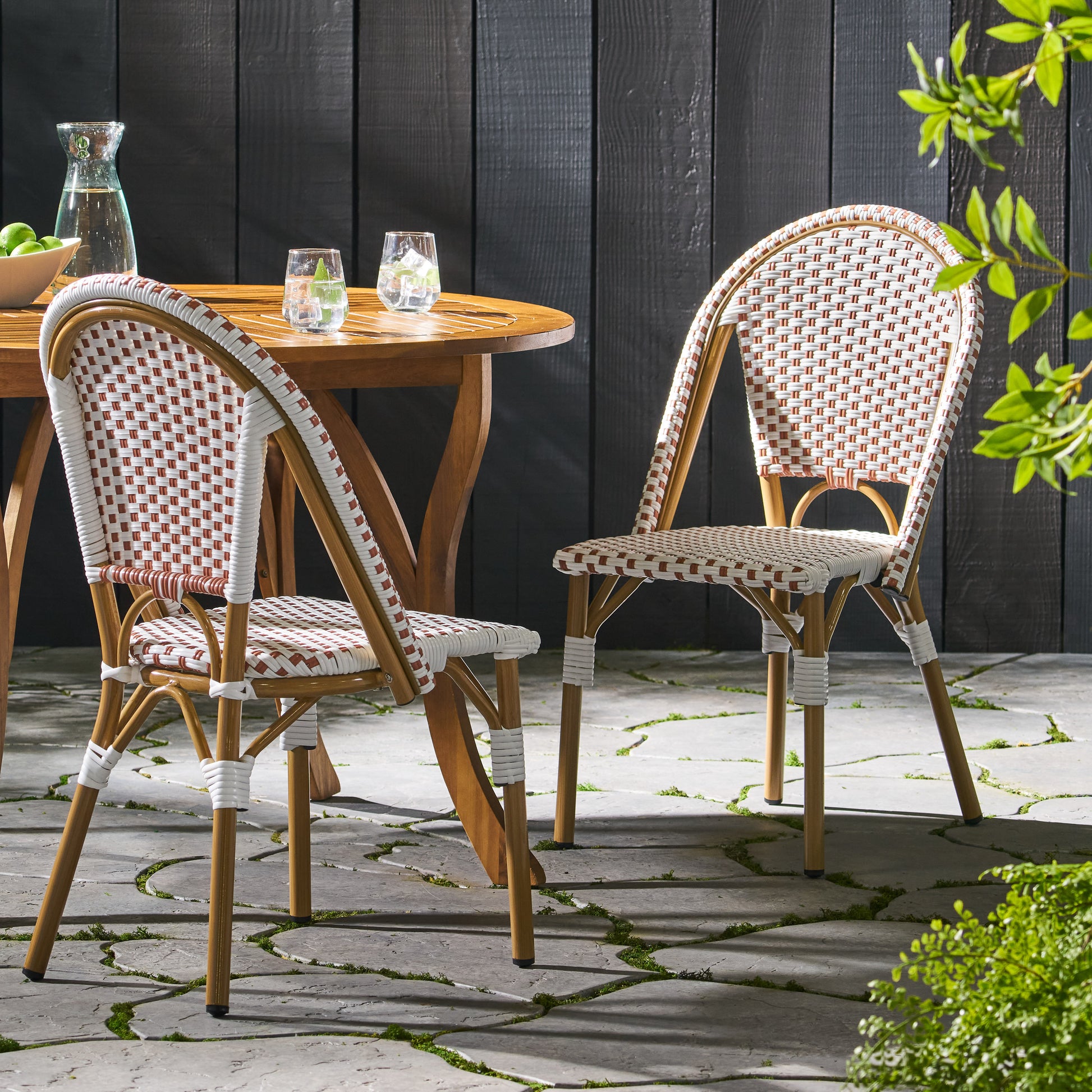 Two wicker cafe chairs with brown and white weaving and curved wooden frames perfect for outdoor bistro settings