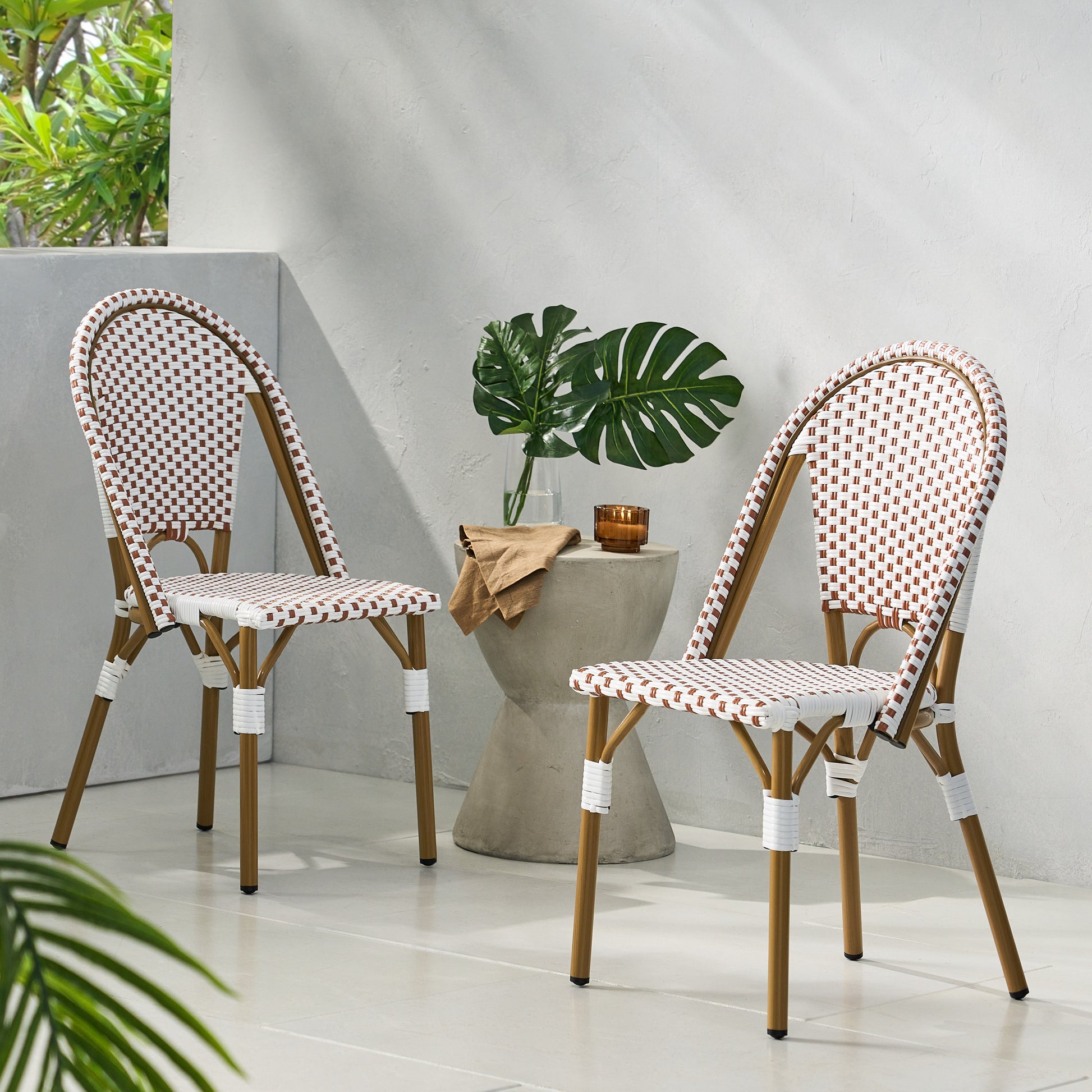 Two white and brown rattan bistro chairs with wooden legs and curved backs perfect for outdoor dining
