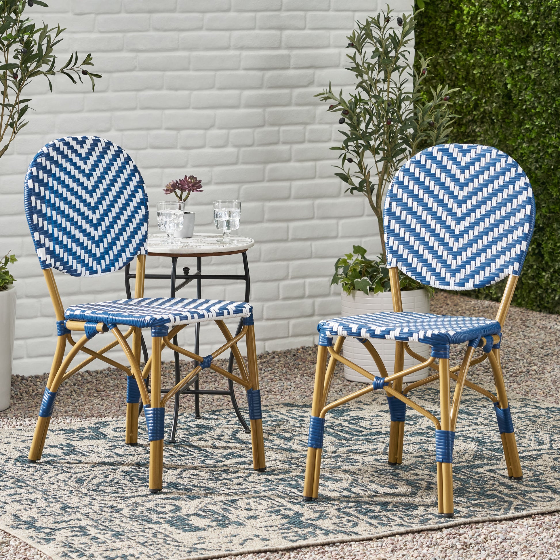 Two blue and white zigzag bistro chairs with rattan accents on an outdoor patio