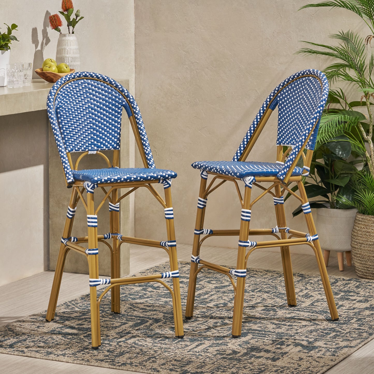 Two blue and white rattan bar stools with woven seats and curved backs perfect for a patio