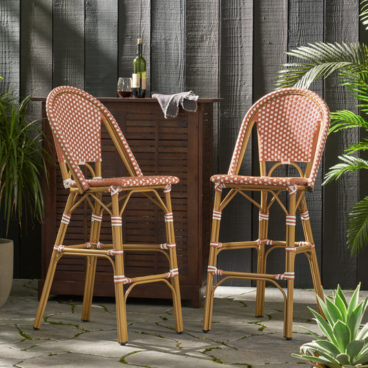 Two terra cotta and white rattan bar stools with curved backs for outdoor seating