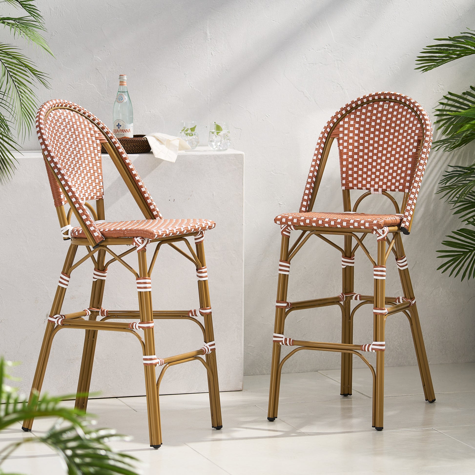 Two brown and white woven bar stools with gold metal frames outdoor patio seating