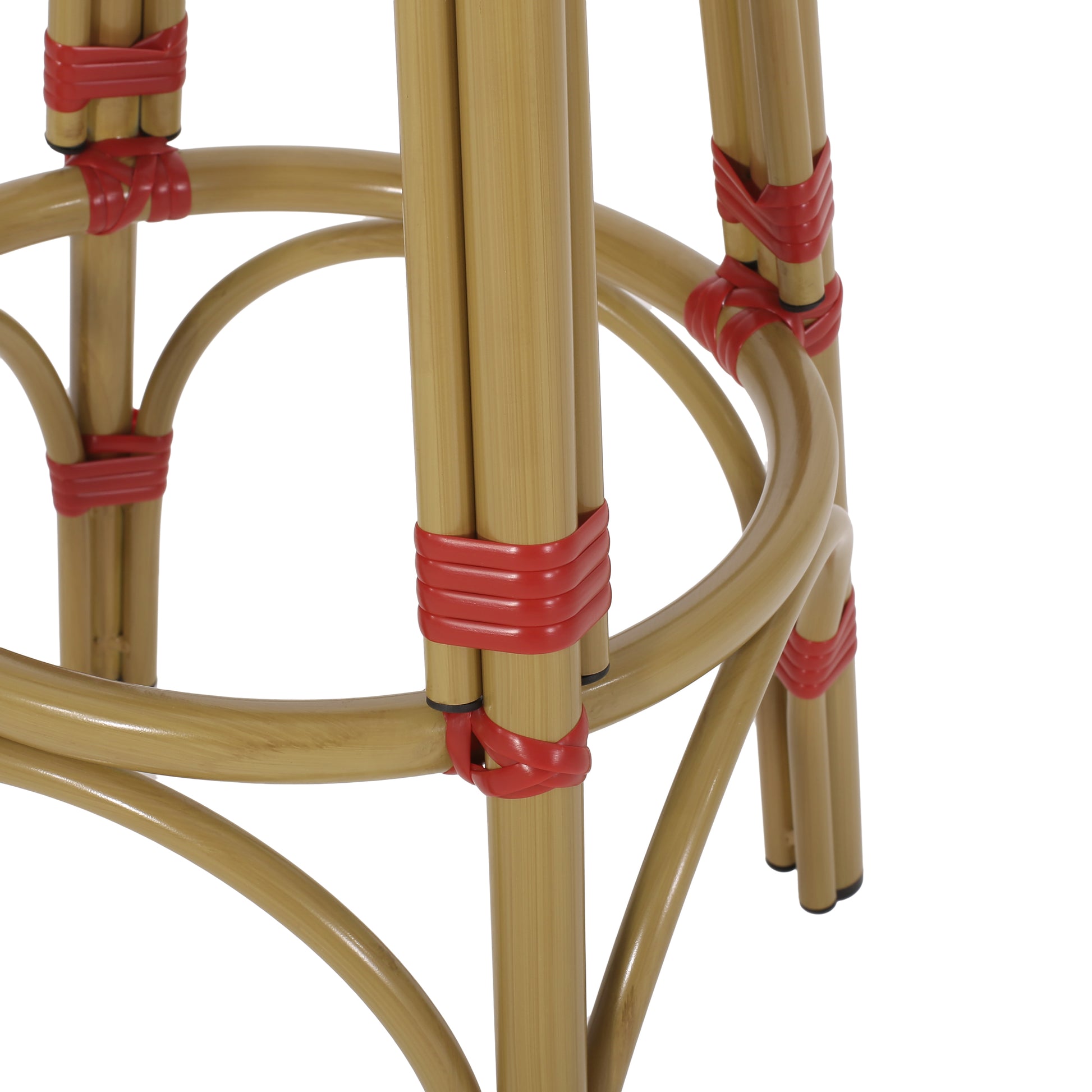Closeup of a light brown bamboo bar stool frame with red rattan accents on legs