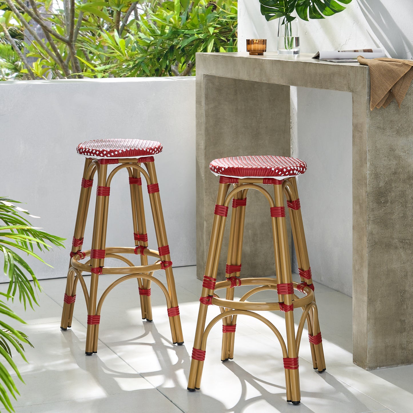 Two wicker bar stools with red and white patterned seats on a patio ideal for outdoor dining
