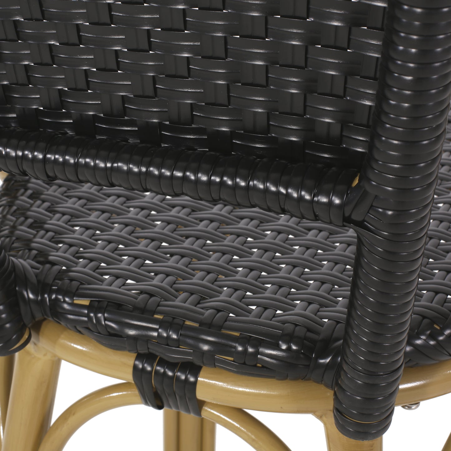 Closeup of black rattan weave on a tan wicker chair frame ideal for outdoor furniture