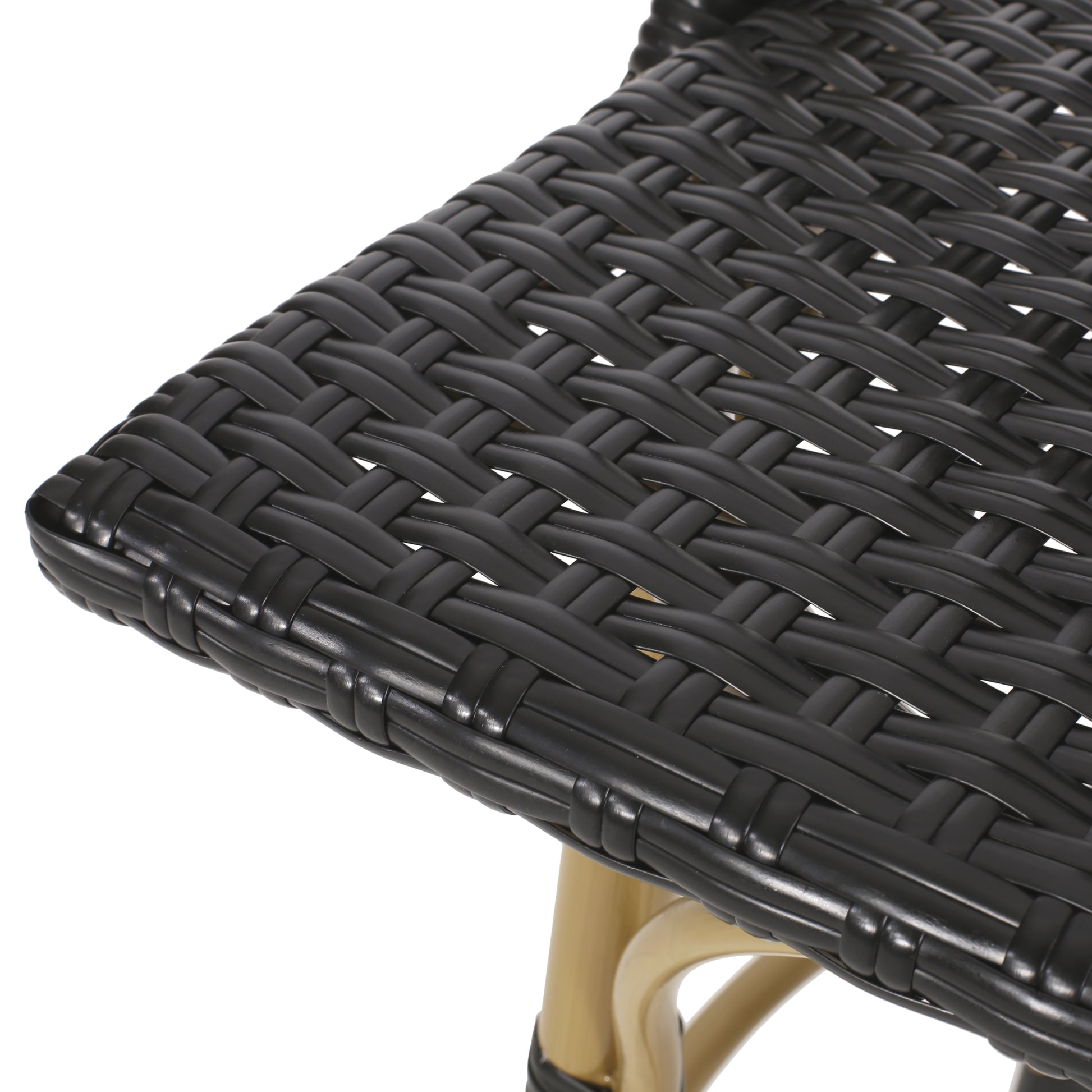 Close up of a black wicker seat with woven texture and gold legs