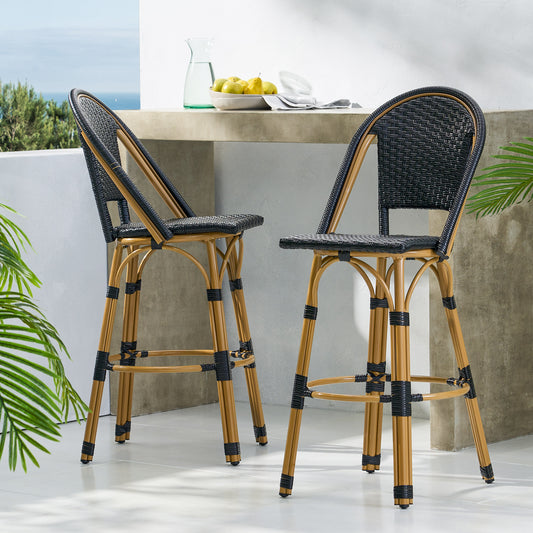 Pair of black woven bar stools with natural bamboo frames on a patio