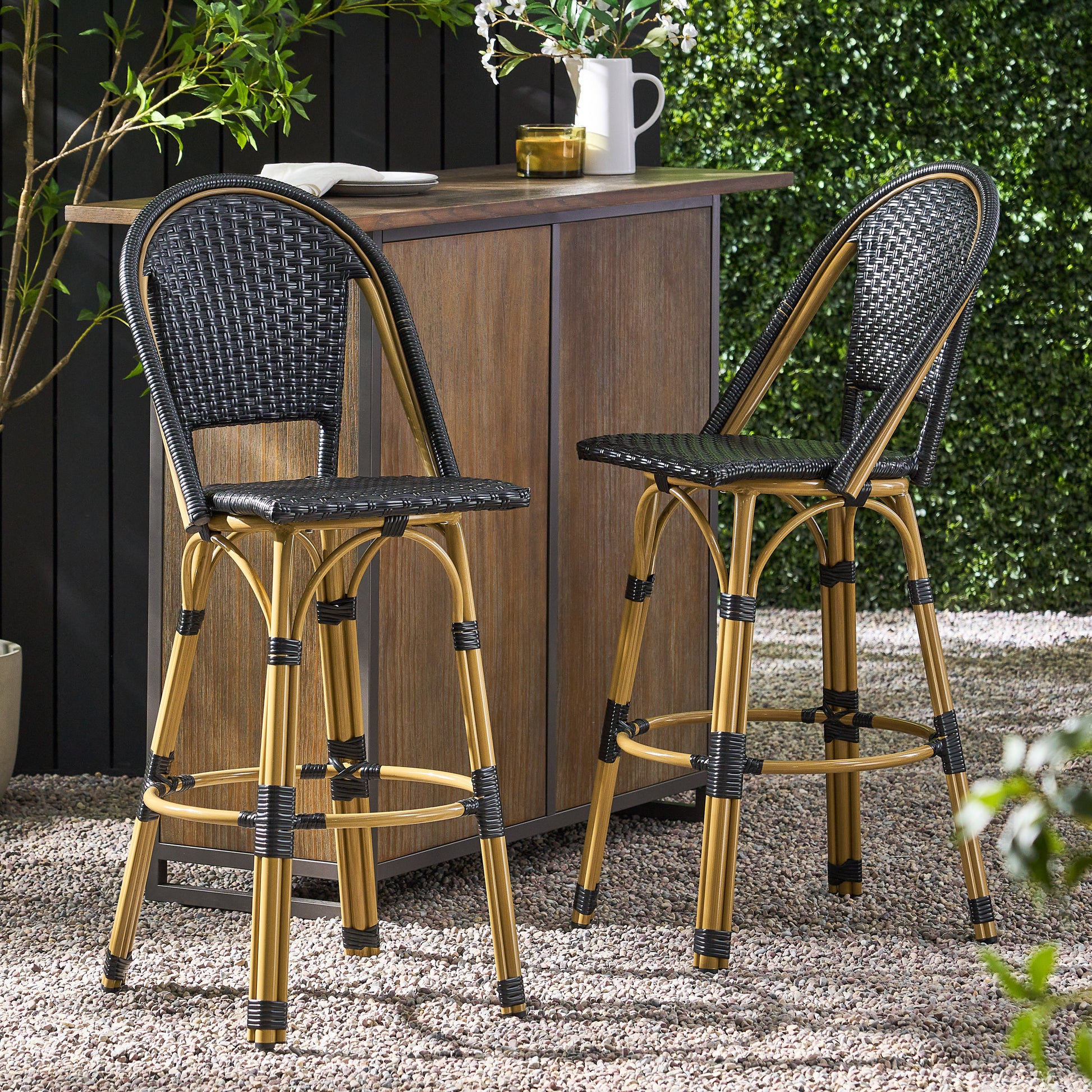Pair of black wicker bar stools with natural bamboolook frames perfect for outdoor entertaining