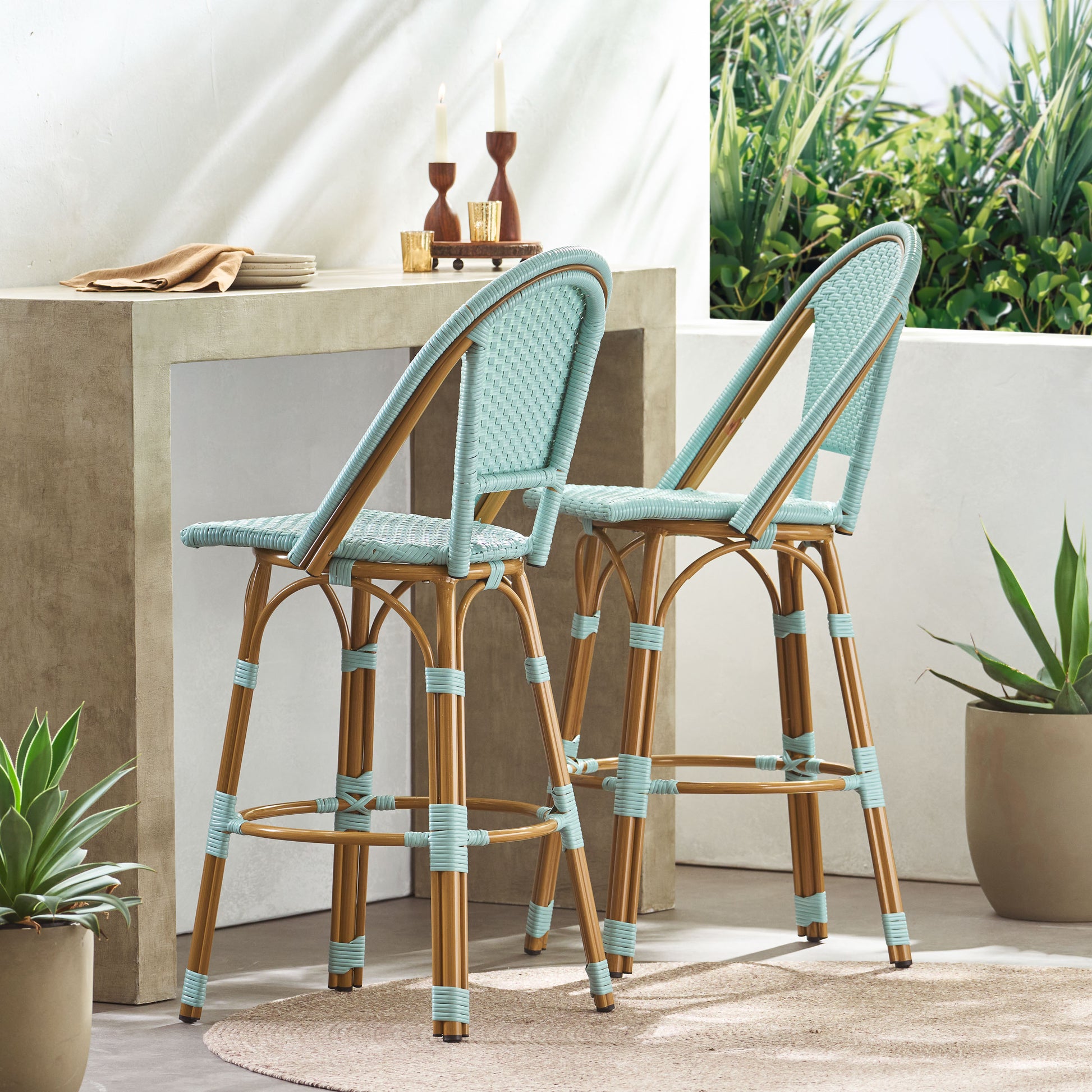 Two light blue rattan bar stools with natural wood legs and accents ideal for outdoor patio seating
