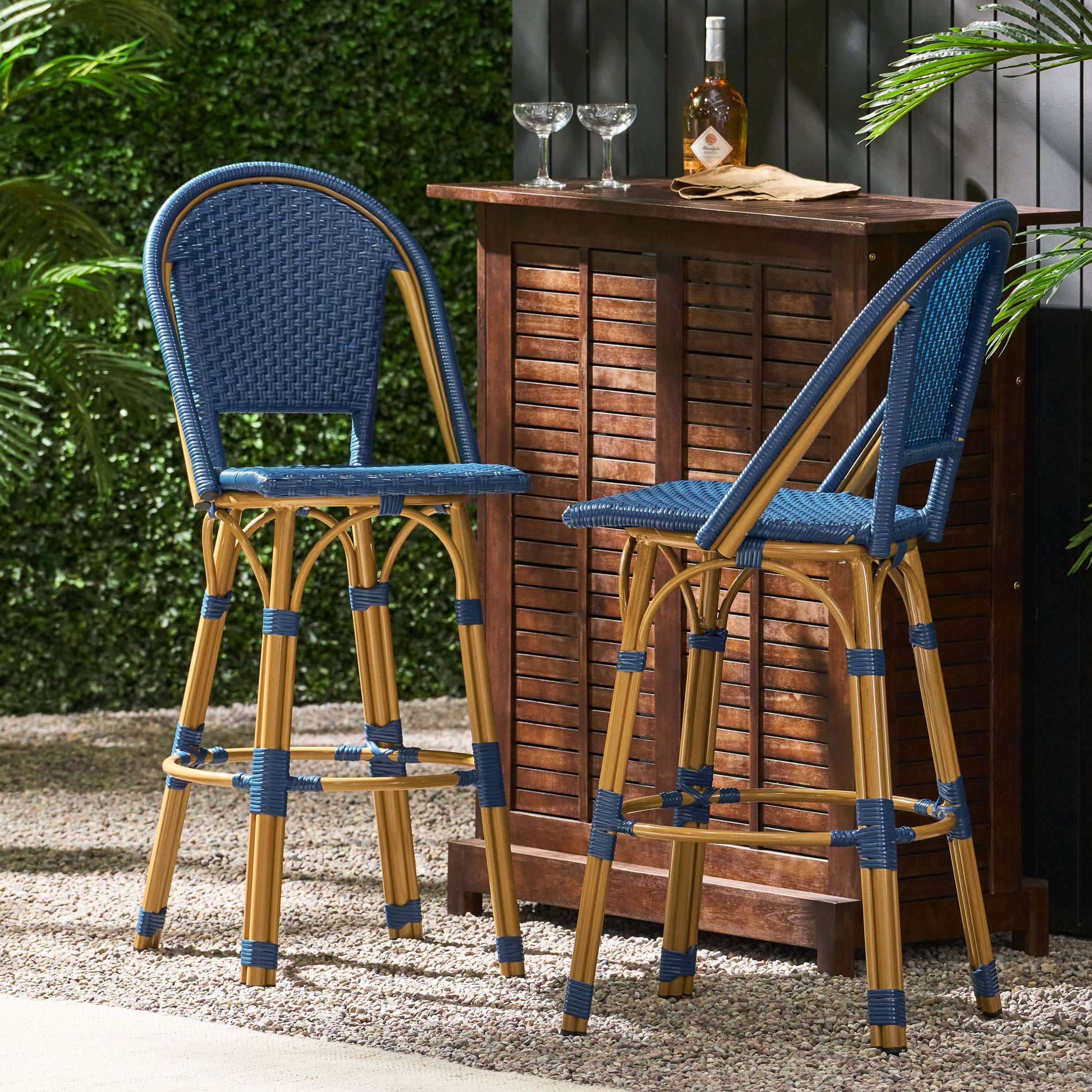 Two blue rattan bar stools with golden bamboo legs perfect for outdoor entertaining