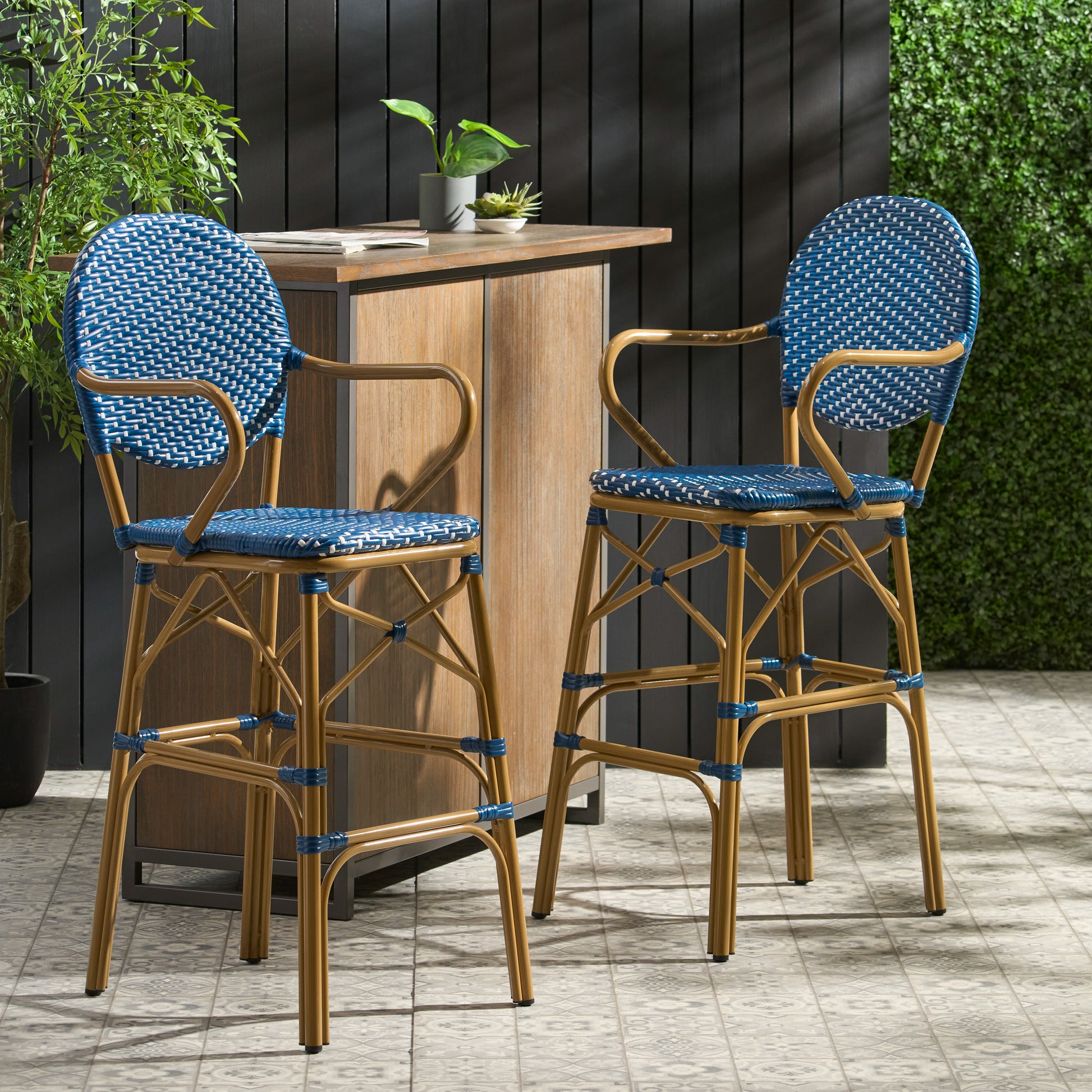 Two blue and white rattan bar stools with gold metal frames perfect for outdoor entertaining