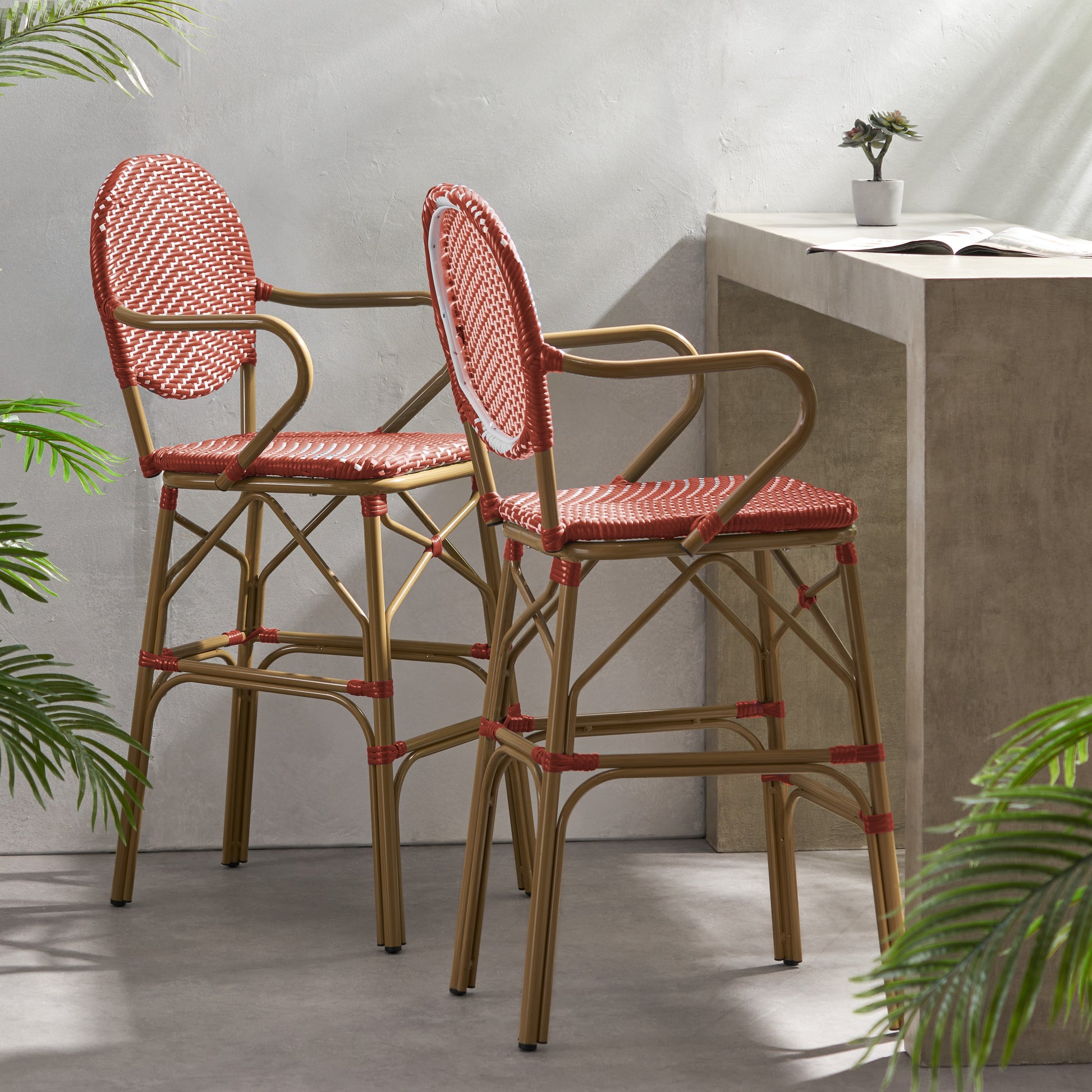 Pair of red woven bistro bar stools with gold metal frames ideal for patios